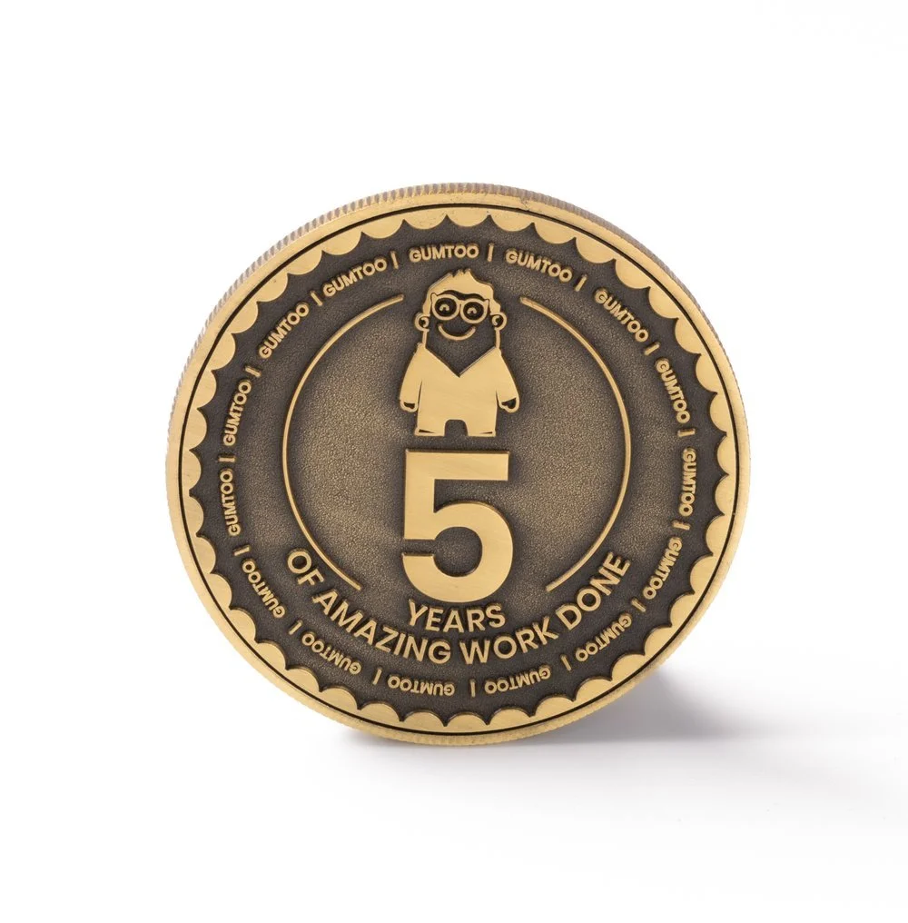 Die struck coin with no enamel colour, showing a recessed and raised design in antique gold