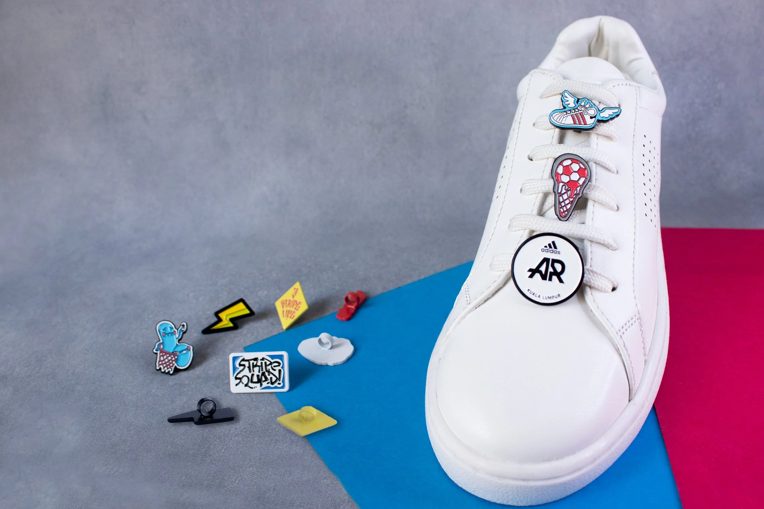 adidas Runners Kuala Lumpur charm with winged sneaker and football cone charms on a white sneaker