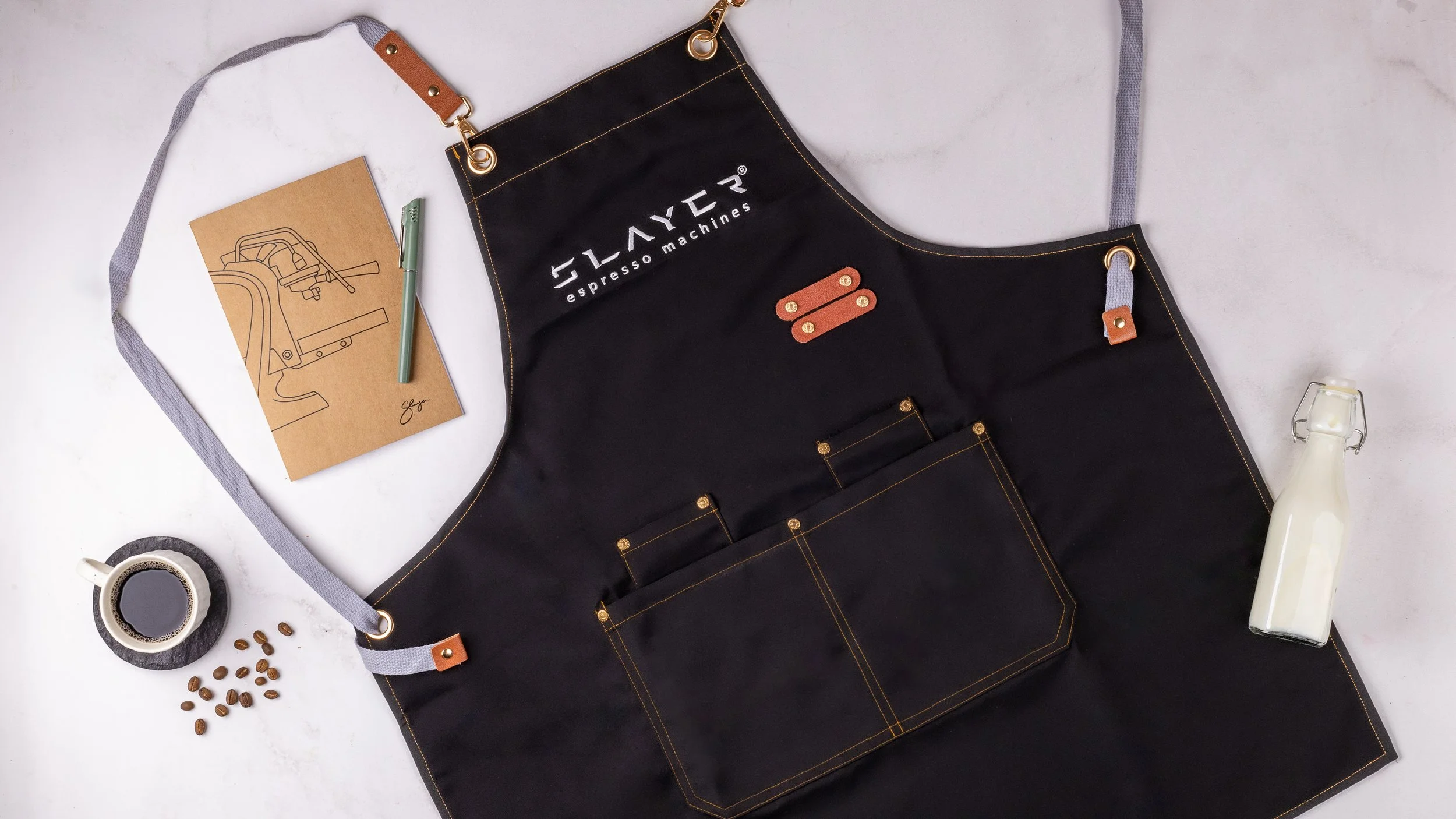 Slayer coffee merchandise for partners, notebook and apron