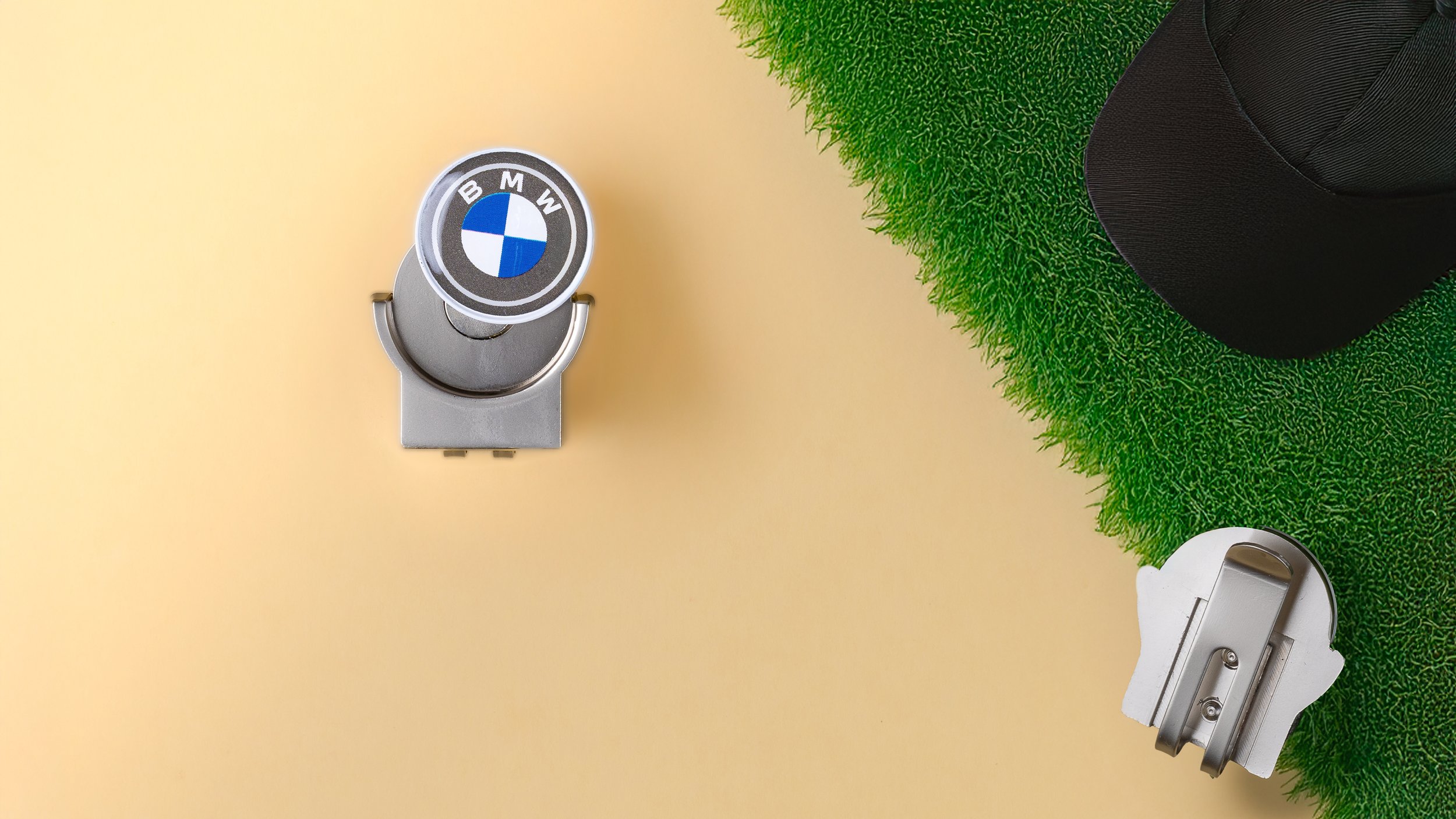 Magnetic hat clip golf ball marker with the BMW roundel, shown front and back beside a cap