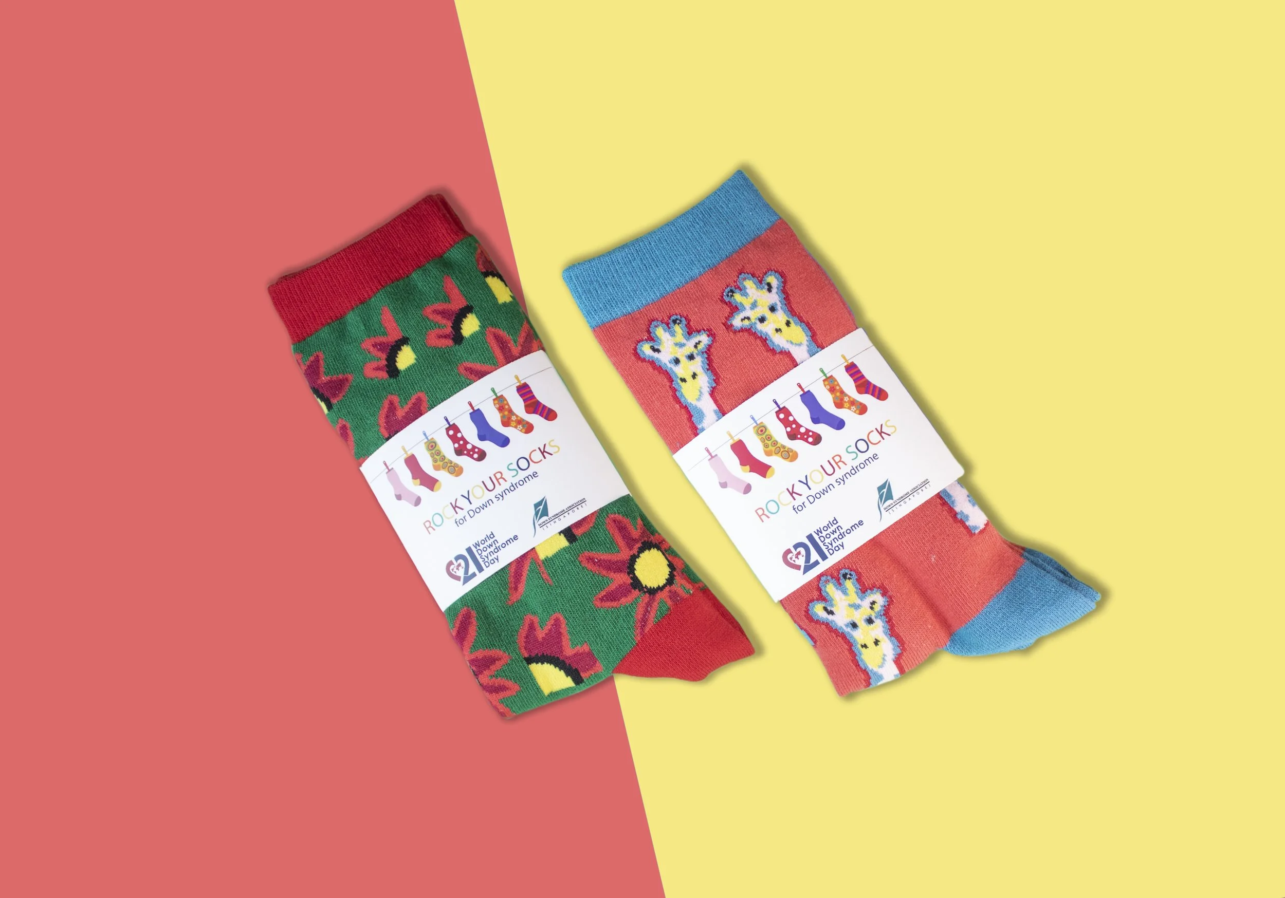 Two pairs of brightly patterned custom socks in printed charity awareness packaging