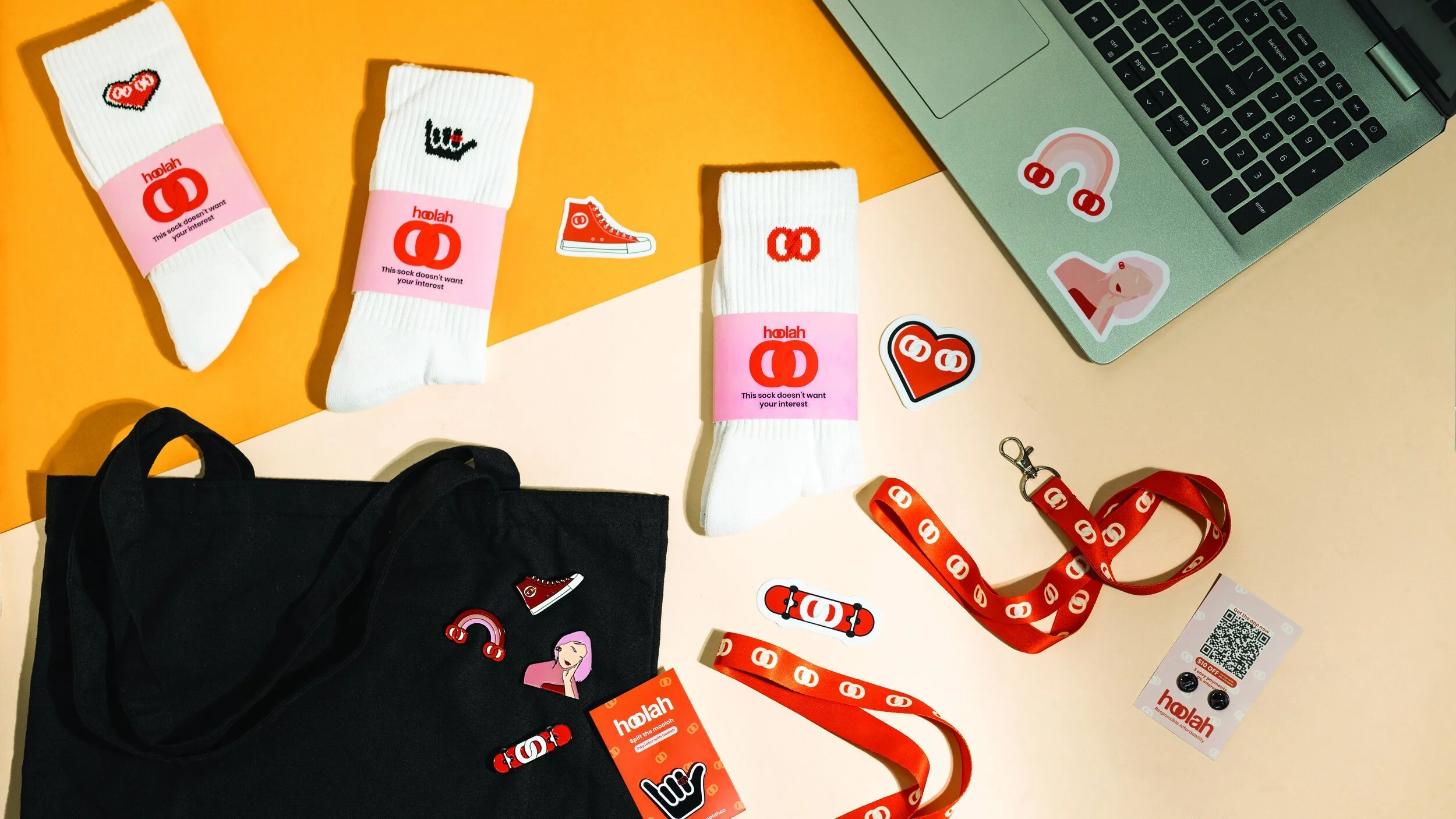 hoolah merchandise kit with knitted socks, a tote bag, enamel pins, lanyards and stickers