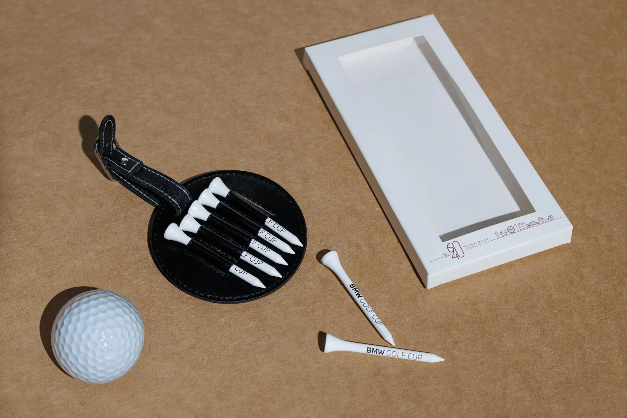 BMW custom golf tee gift set with black tee holder, white logo-printed tees, golf ball and presentation box, premium automotive client golf gift, retail merchandise Malaysia