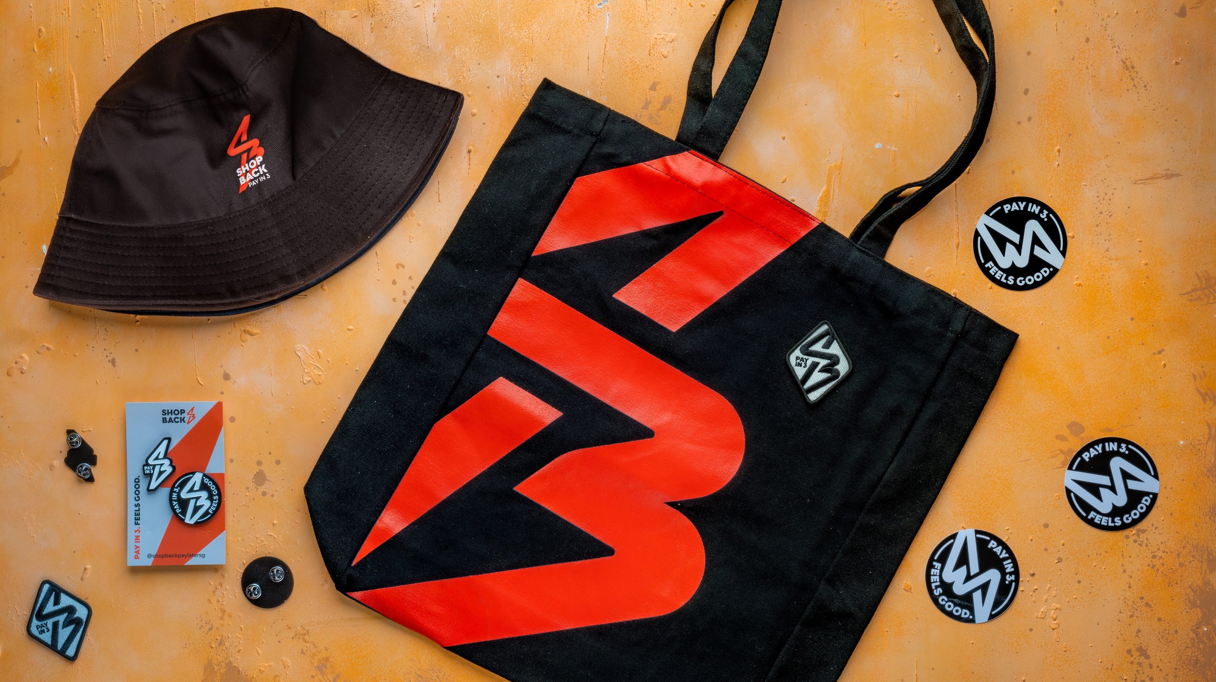 ShopBack Pay in 3 campaign kit with a bucket hat, tote bag, enamel pins, patch and stickers