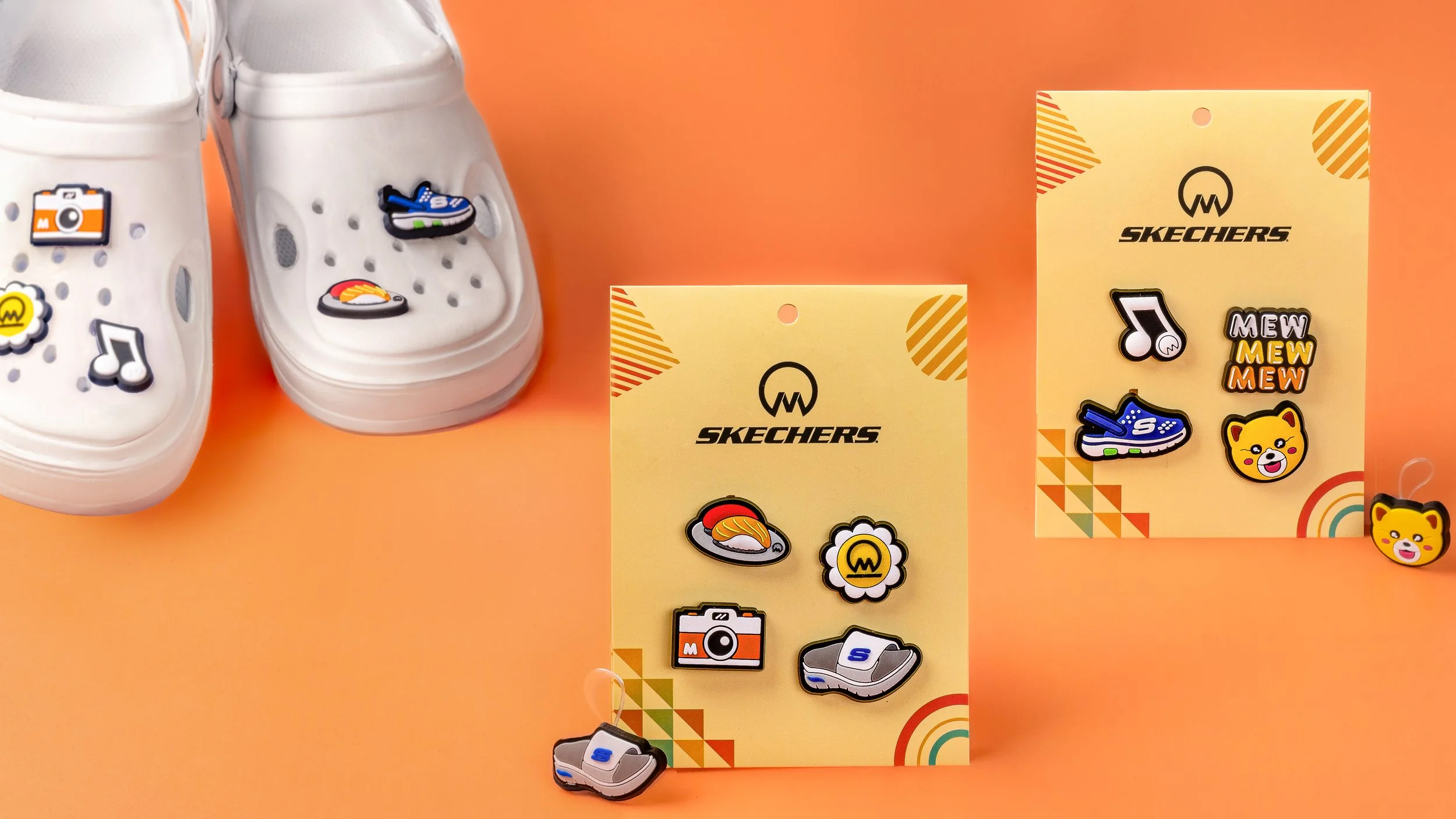 Skechers PVC shoe charms for Gift with Purchase on retail backing cards, with charms fitted to a pair of white clogs