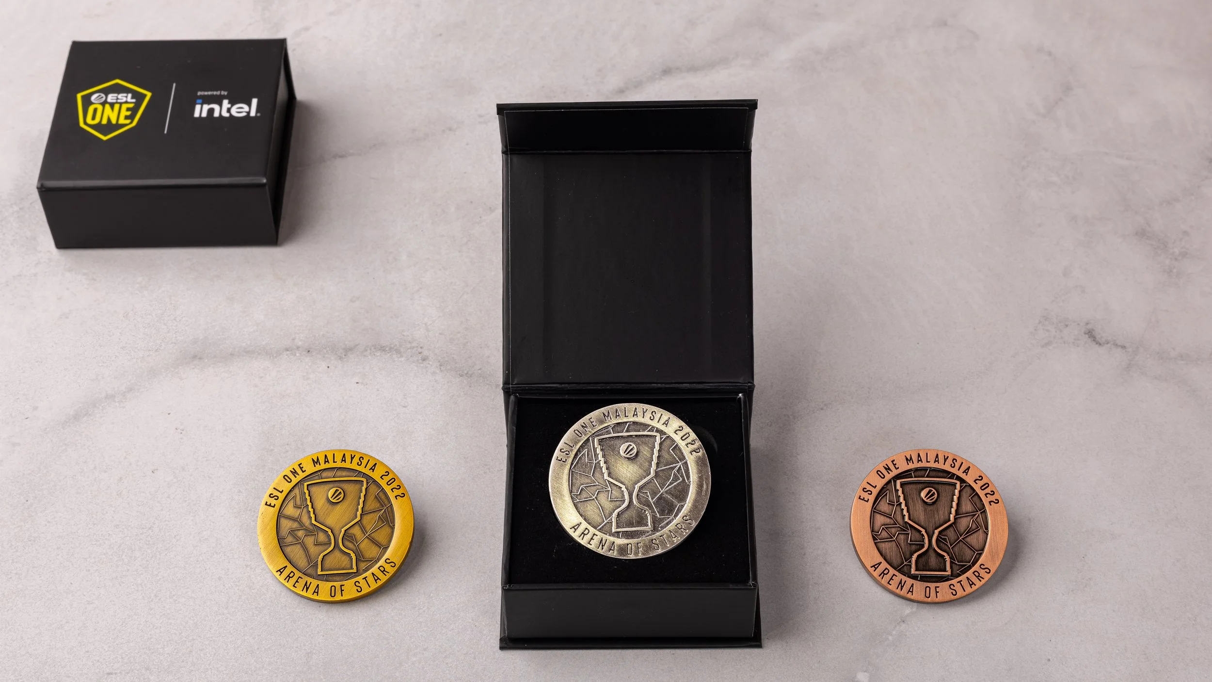 Gold, silver and bronze ESL One Malaysia 2022 Arena of Stars coins with the branded presentation box