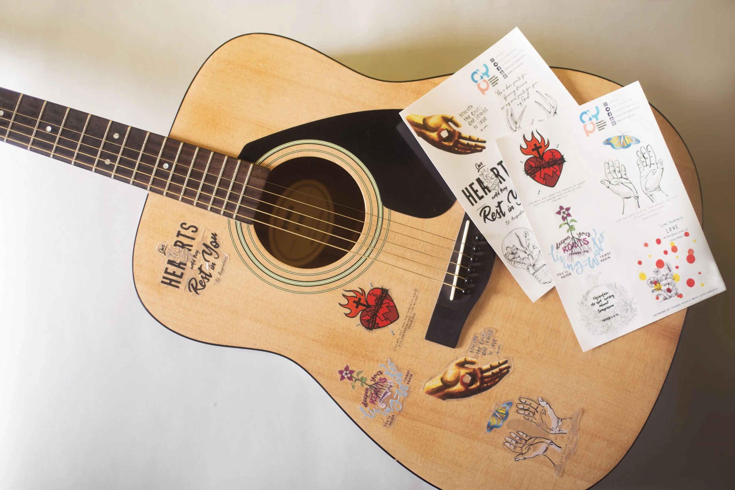 CYP faith-inspired transparent vinyl stickers applied to an acoustic guitar with matching kiss-cut sticker sheets