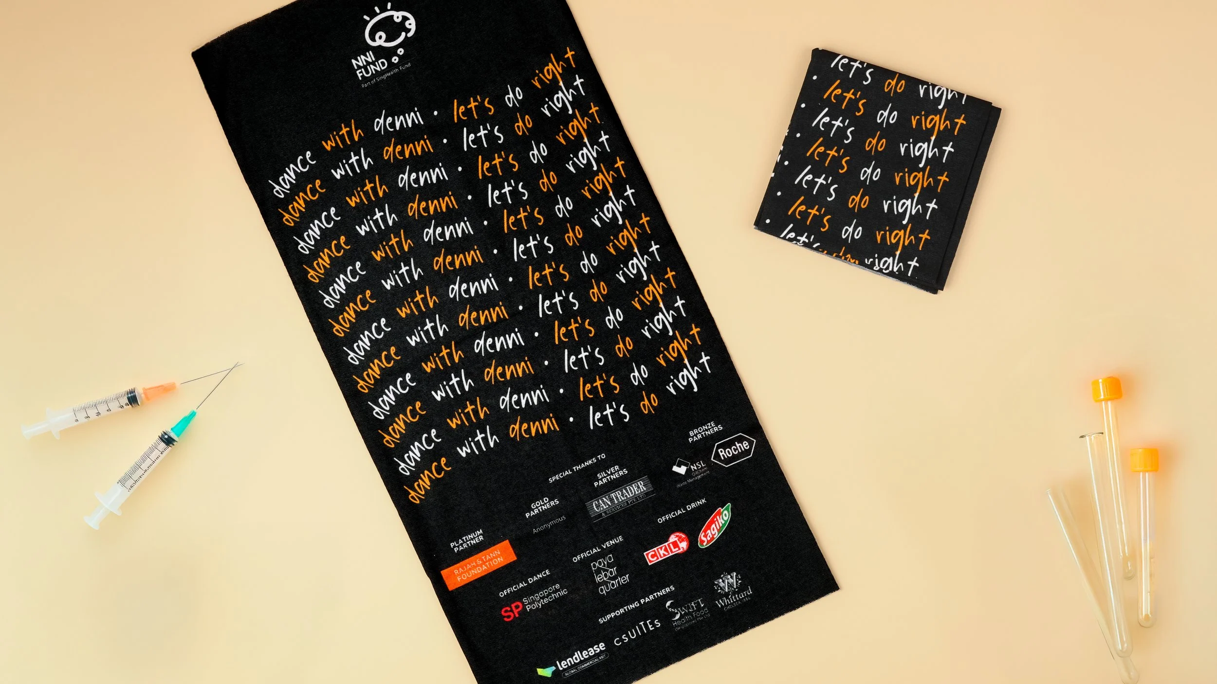 Black tube bandana for the NNI Fund 
charity event, printed with repeated slogans 
and a sponsor logo panel