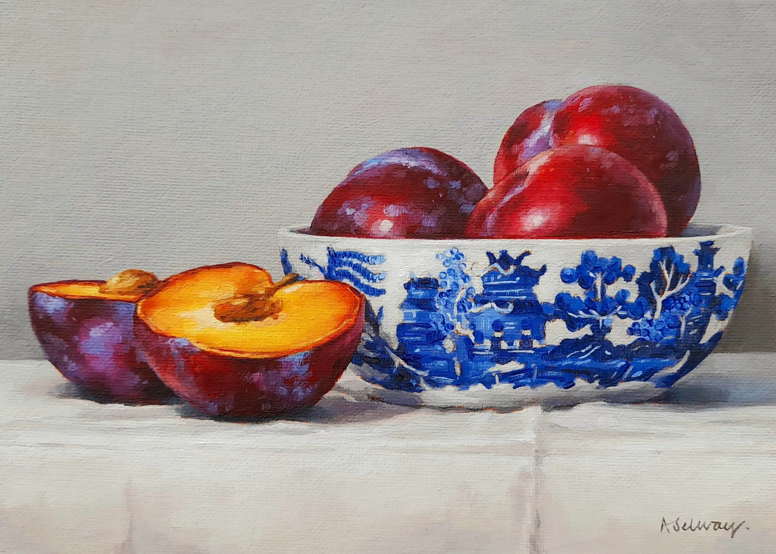 A still life painting of a blue and white patterned bowl filled with red apples and purple grapes, with a sliced yellow apple in the foreground, on a light-colored surface
