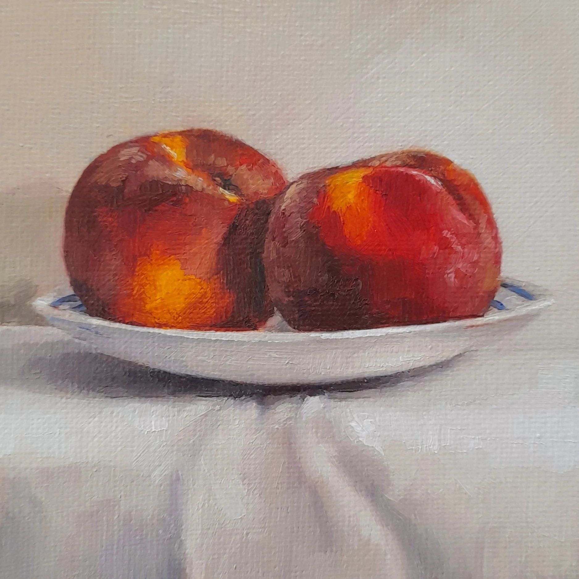 Small oil painting of two ripe peaches on a white plate, resting on a white cloth against a soft neutral background.