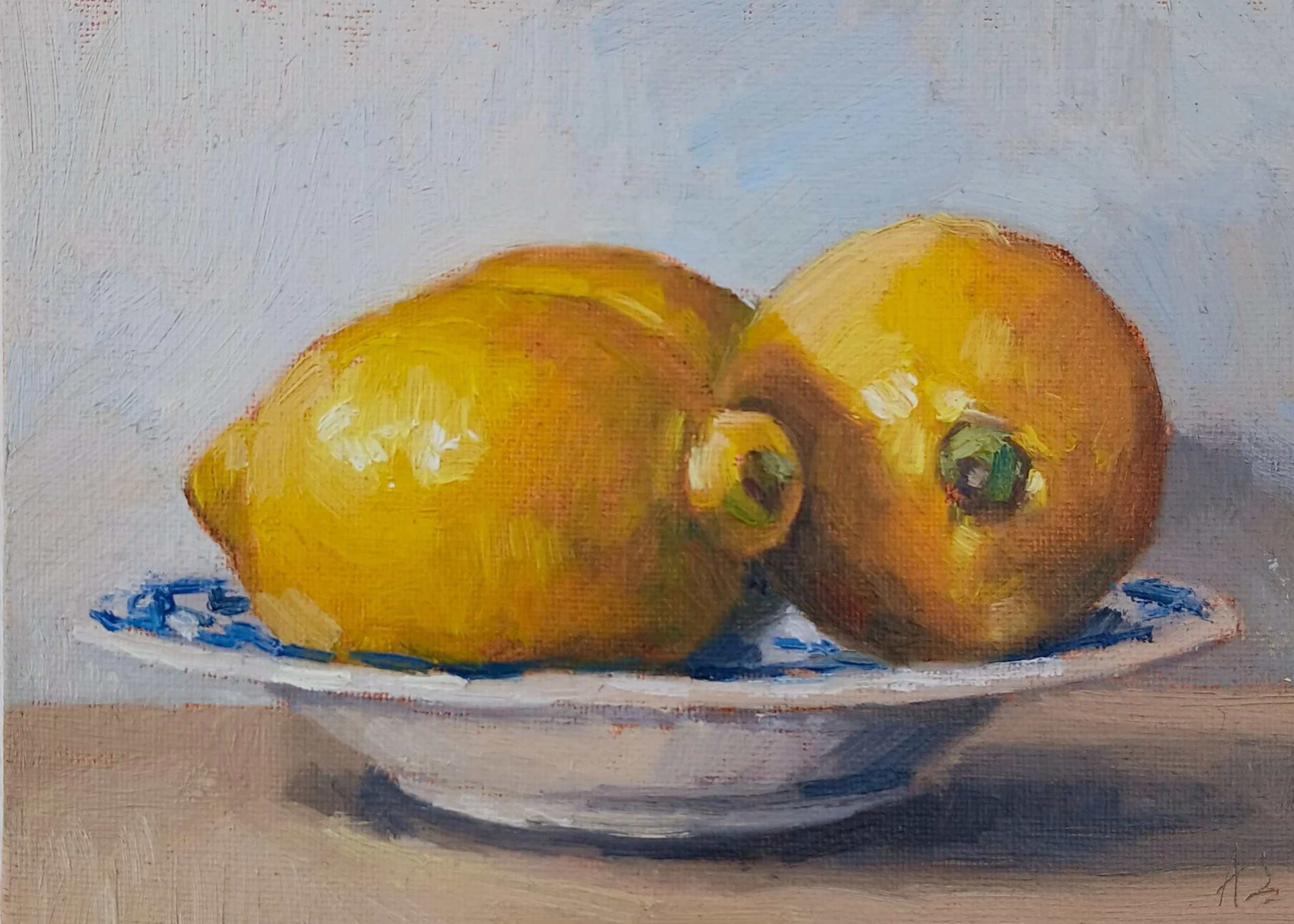 Still Life oil painting of three yellow lemons on a blue and white decorative plate, with a light background.