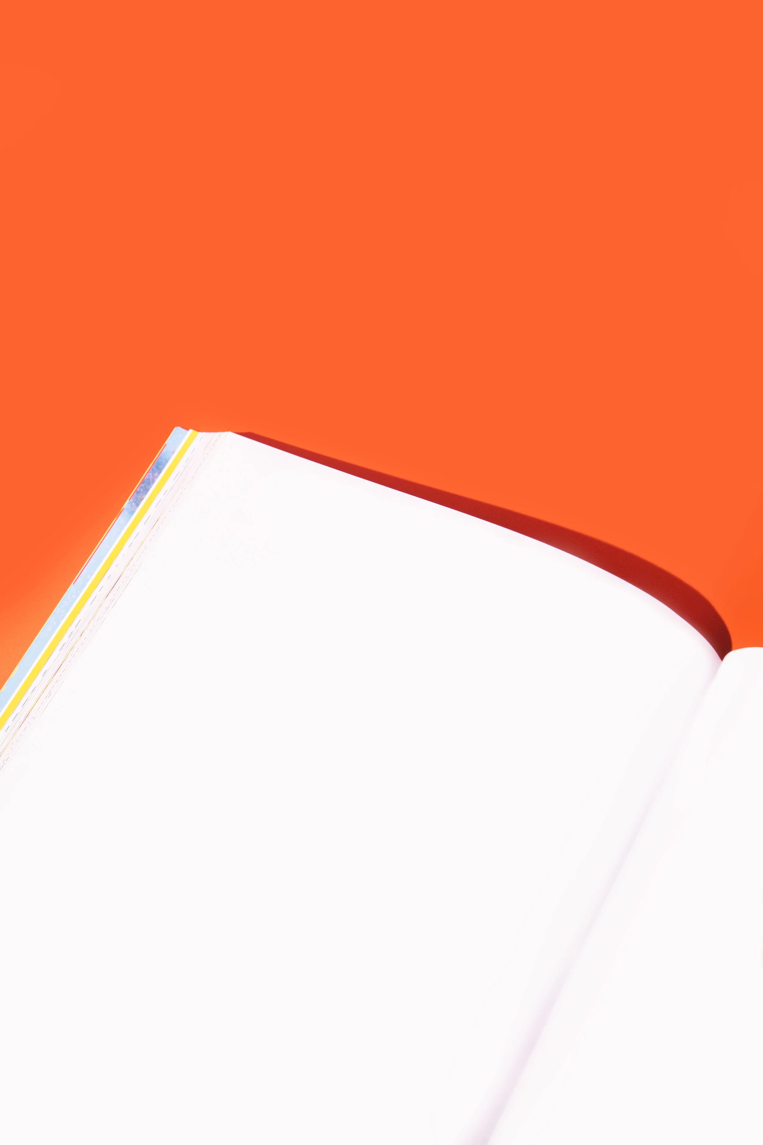 Blank book in front of orange background.