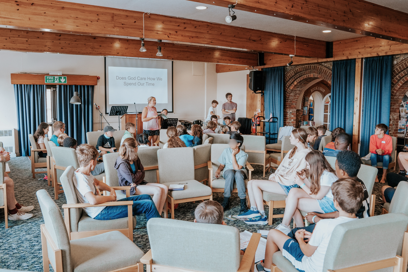 A group of teenagers listening to Bible teaching in a converted barn.