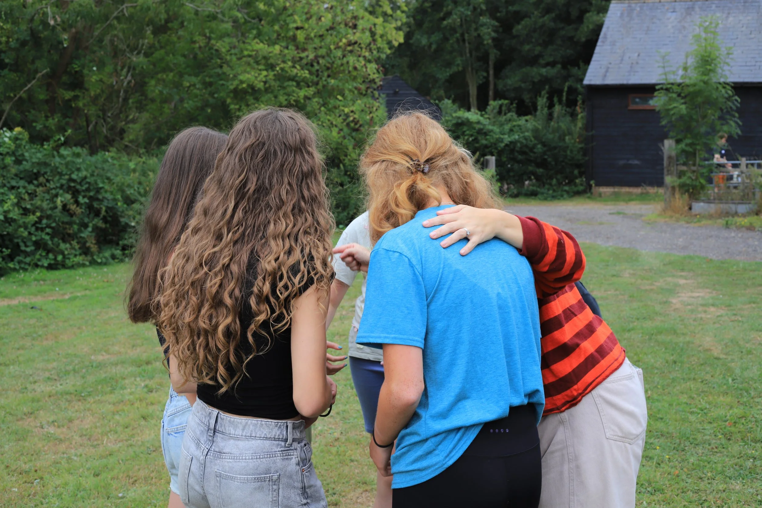 A huddle of teenage girls discussing game tactics.