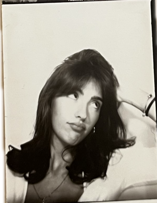 Black and white photo of a woman with dark, shoulder-length hair, looking slightly upward and to her left, with a thoughtful expression.