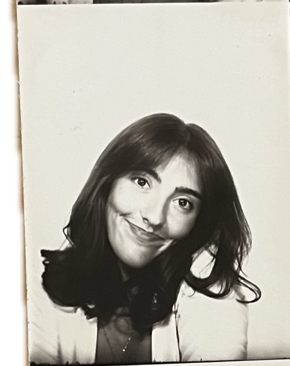 Black and white portrait of a woman with shoulder-length dark hair, smiling softly, wearing a light-colored blazer.
