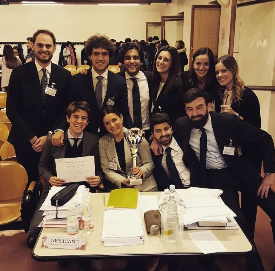Group of young professionals celebrating with a trophy and certificate at a formal event