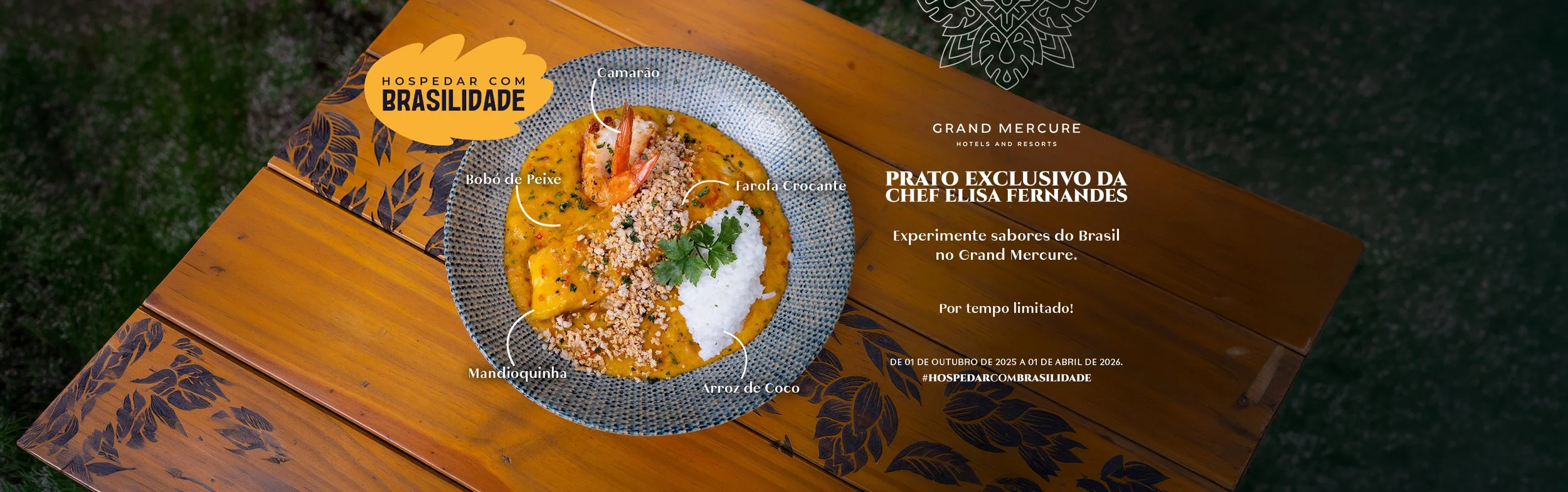 A colorful plate of Brazilian shrimp and coconut rice with toppings of ground nuts, served on a blue patterned plate, placed on a wooden table with a decorative black leaf pattern, with text overlay in Portuguese describing a special dish by Chef Elisa Fernandes at Grand Mercure.