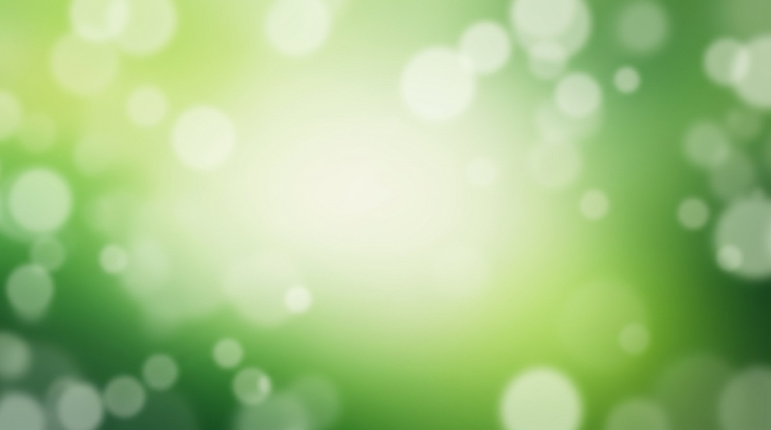 Grüner, unscharfer Hintergrund mit Lichtflecken.