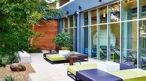Outdoor patio area with modern seating and large glass windows of a building
