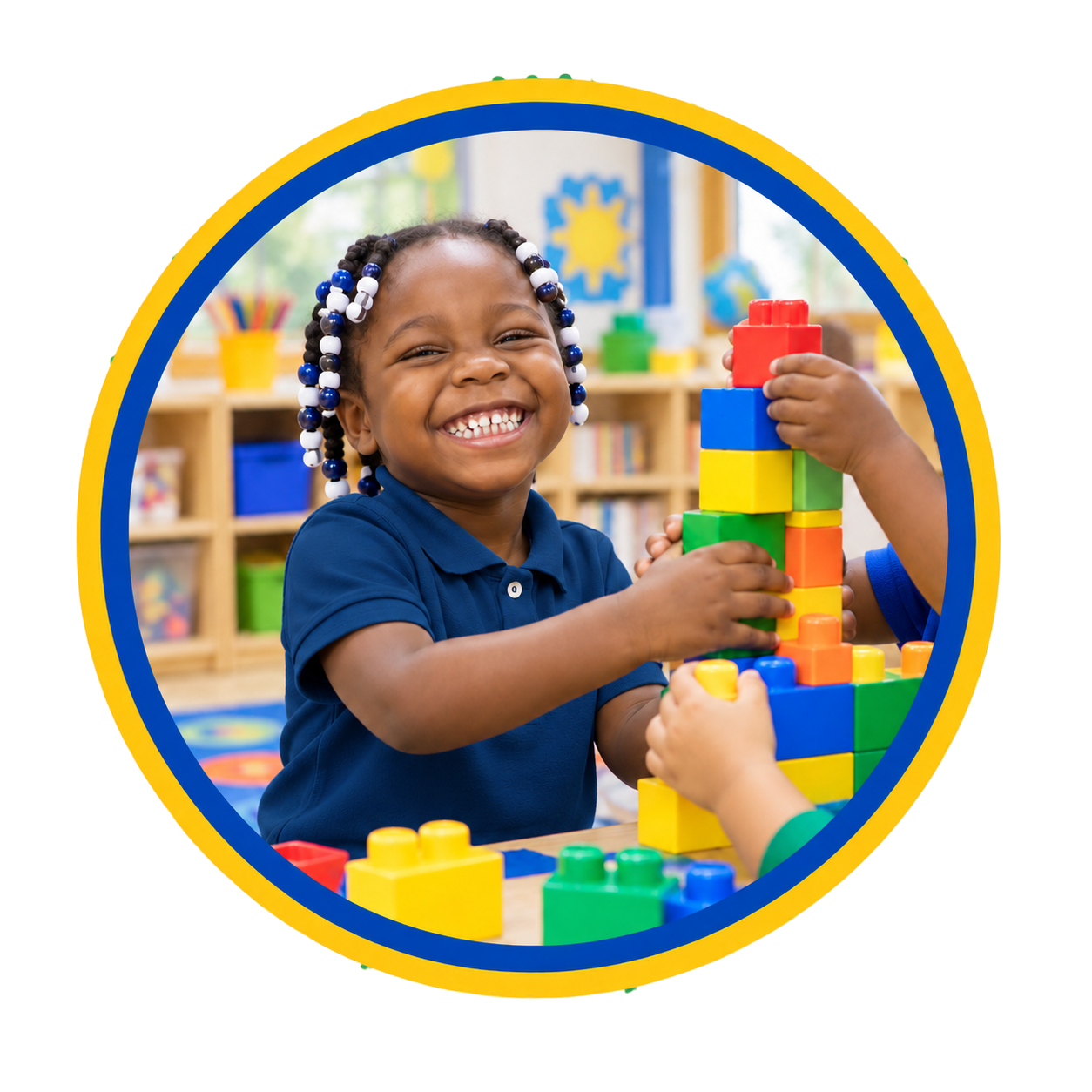 A young girl with beads in her hair, smiling as she stacks colorful building blocks in a classroom.