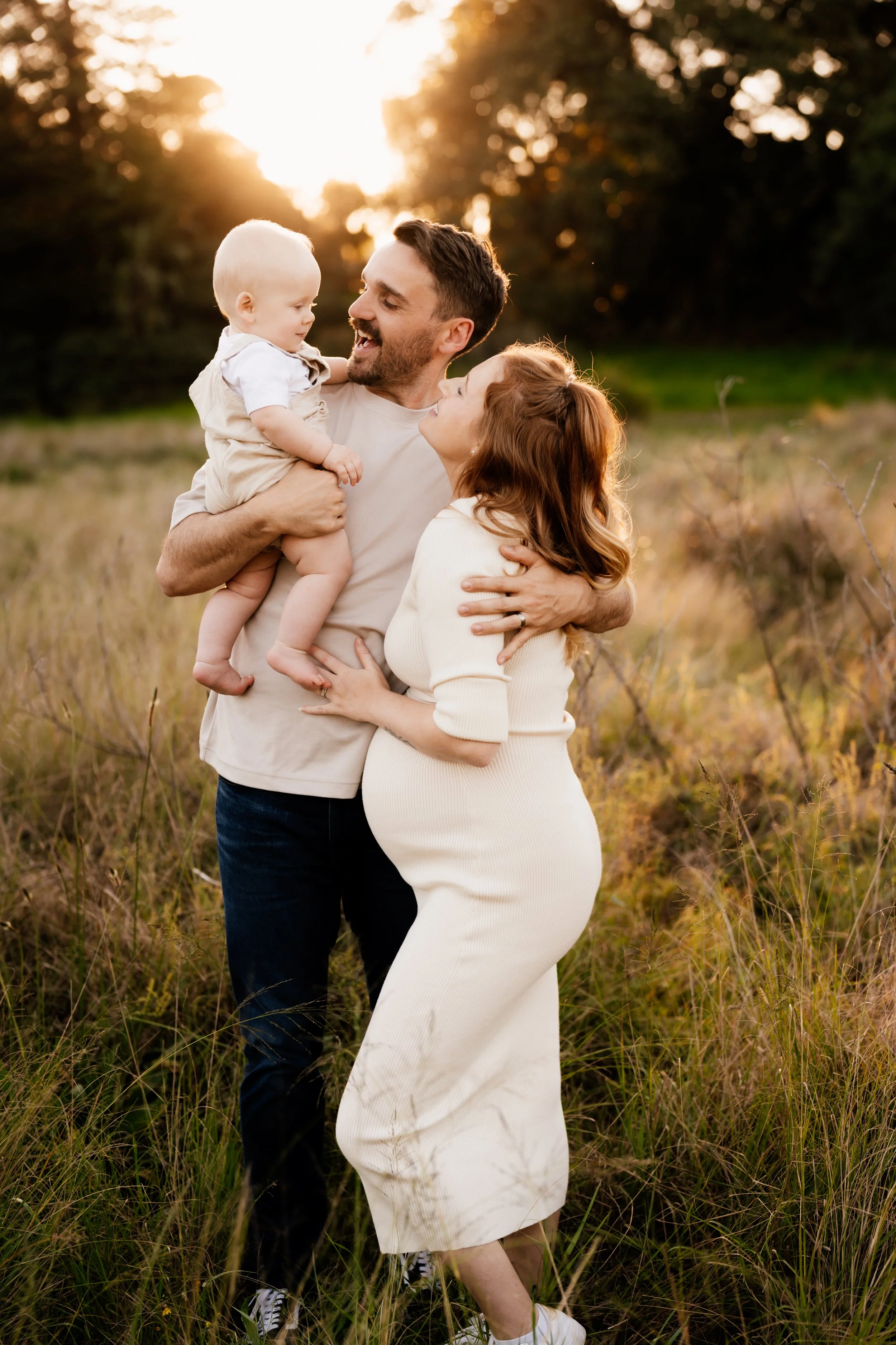 Madi with her husband and baby outdoors.