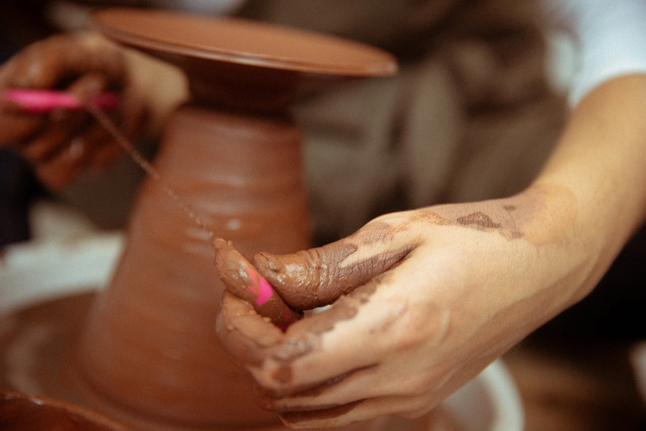 Close-up of hands and a person's torso, with the person applying lotion or oil on their skin.