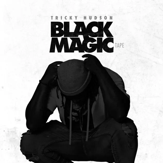 Black-and-white cover art for Tricky Hudson’s “Black Magic” tape, featuring a seated person in dark clothing and a hat covering their face.