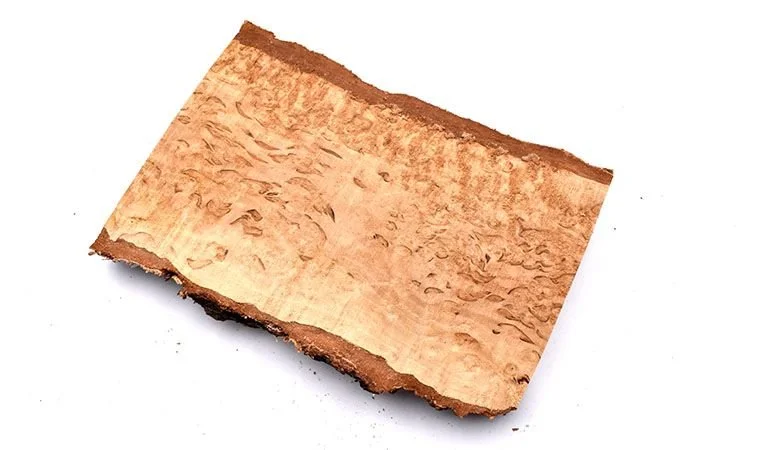 A piece of curly birch plank with a reddish-brown color and textured surface.