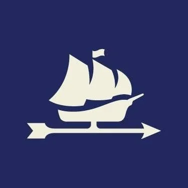 White sailing ship icon on a dark blue background with an arrow underneath.