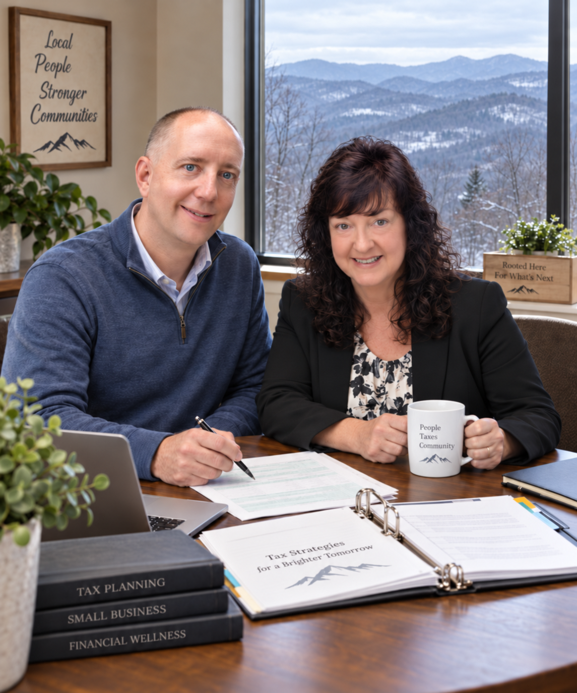 A man and woman sitting at a desk with documents about tax strategies and planning, surrounded by books on tax planning, small business, and financial wellness, in a room with large window showing a snowy mountain landscape.