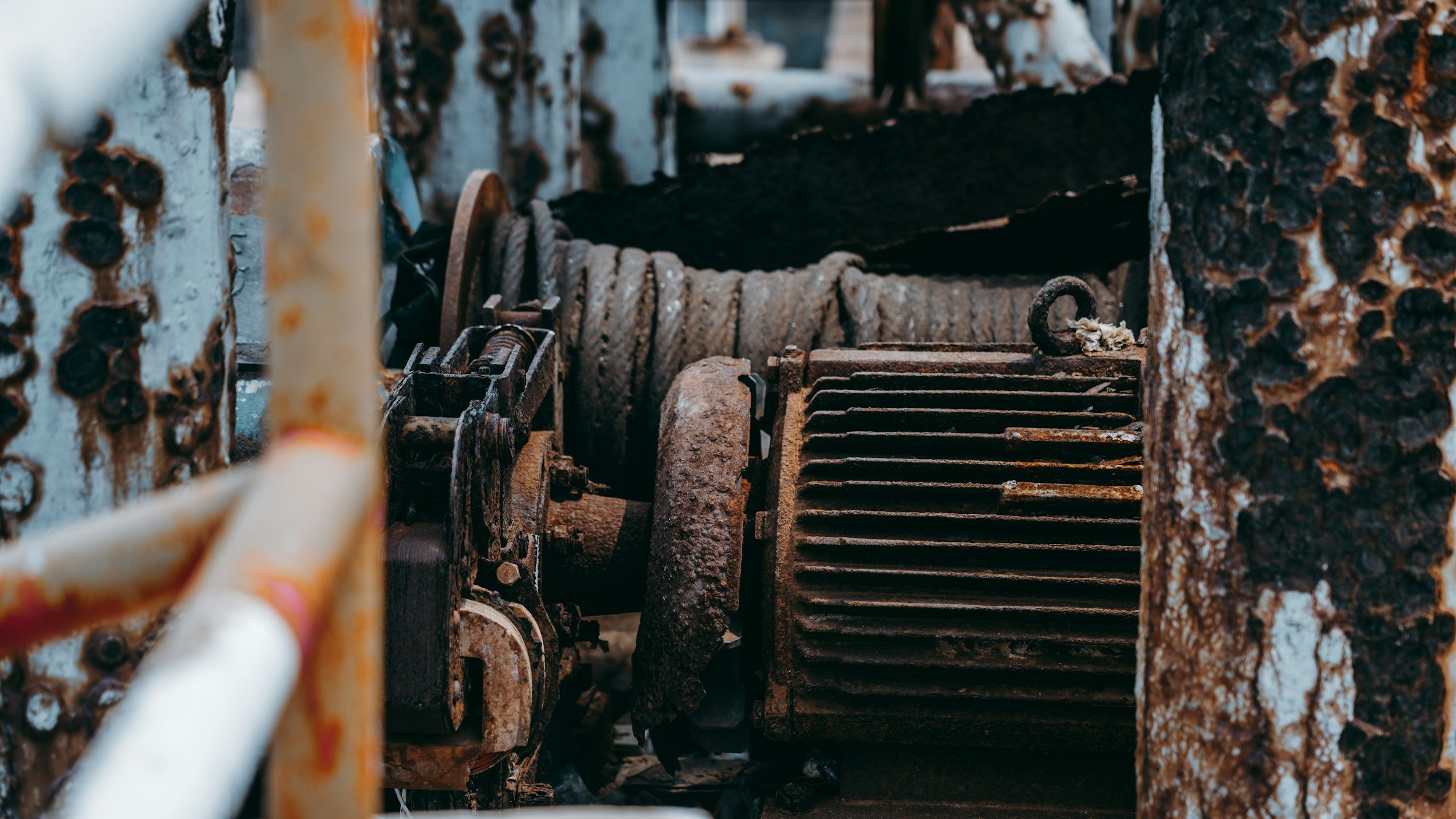 Componenti metallici arrugginiti, ruote dentate e cavi in una macchina abbandonata o rusty