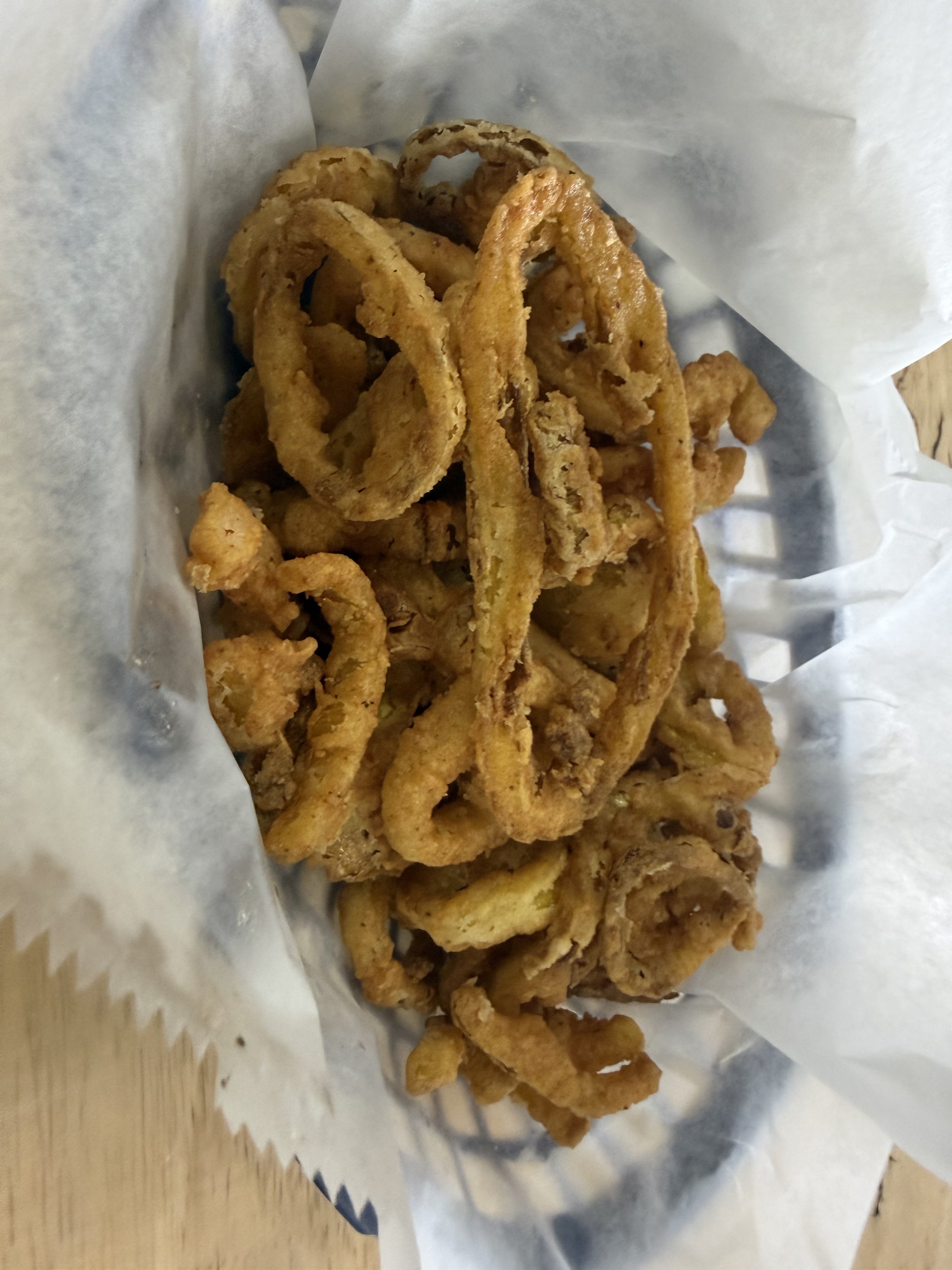 Fried onion rings on a sheet of parchment paper.