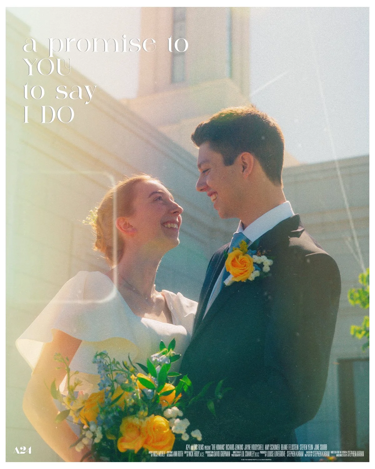 A newlywed couple smiling at each other outdoors, with the bride holding a colorful bouquet, in front of a building, with sunlight creating a warm glow.