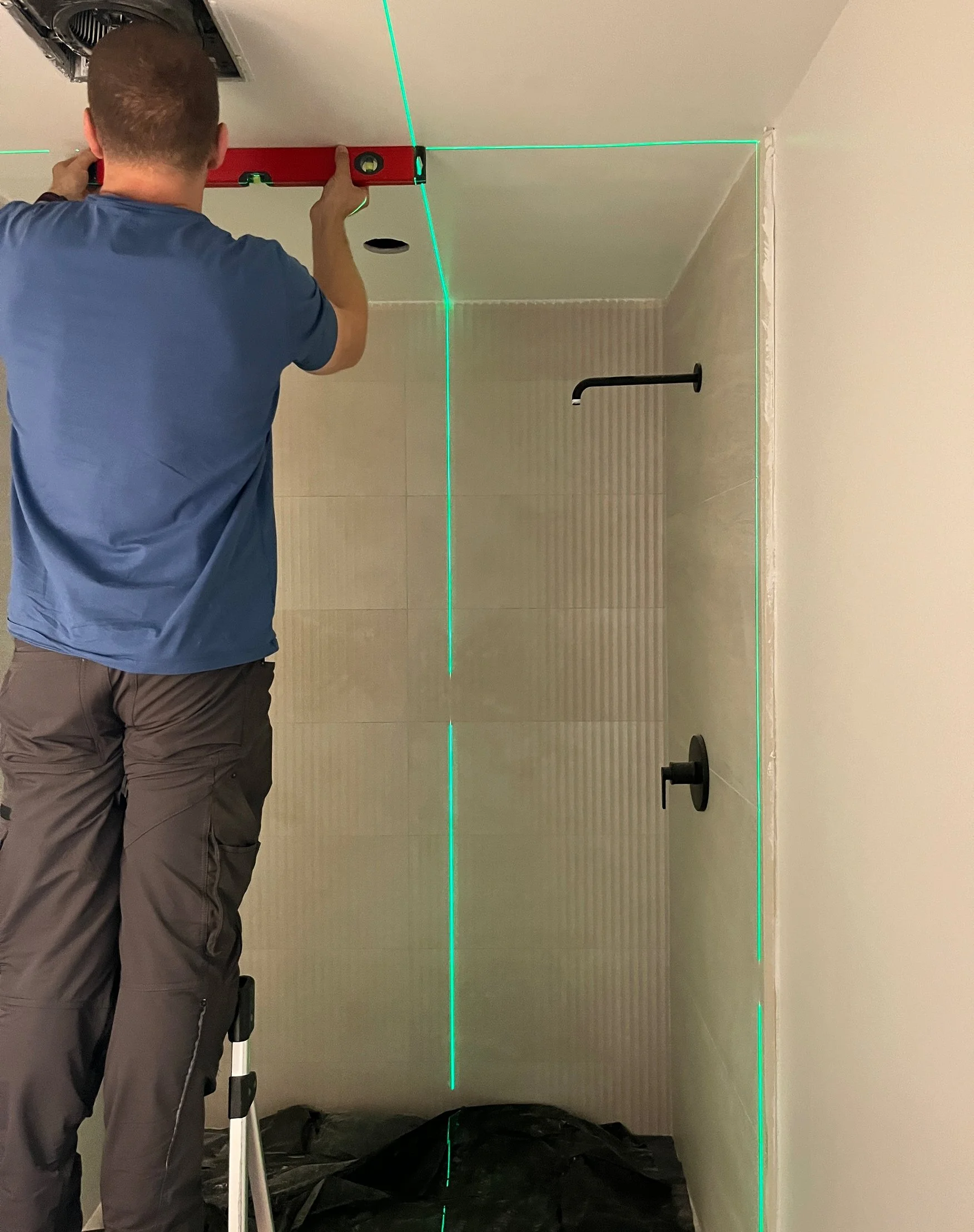 Precision matters for a frameless glass enclosure — the laser lines make sure every measurement is dead-on before the glass gets cut.