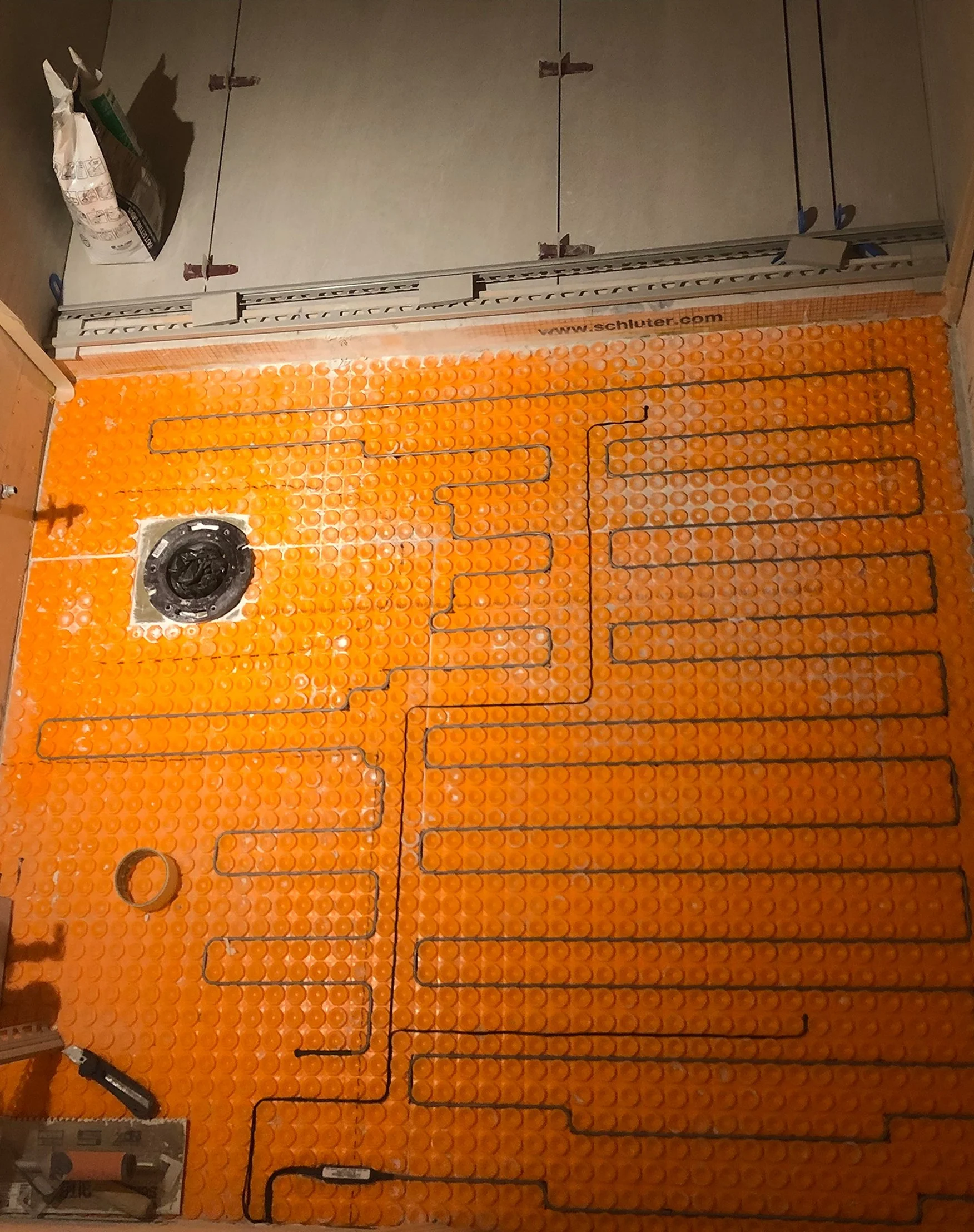 In-floor heating wire laid into a Schluter membrane before tiling, during the Queen West condo bathroom renovation