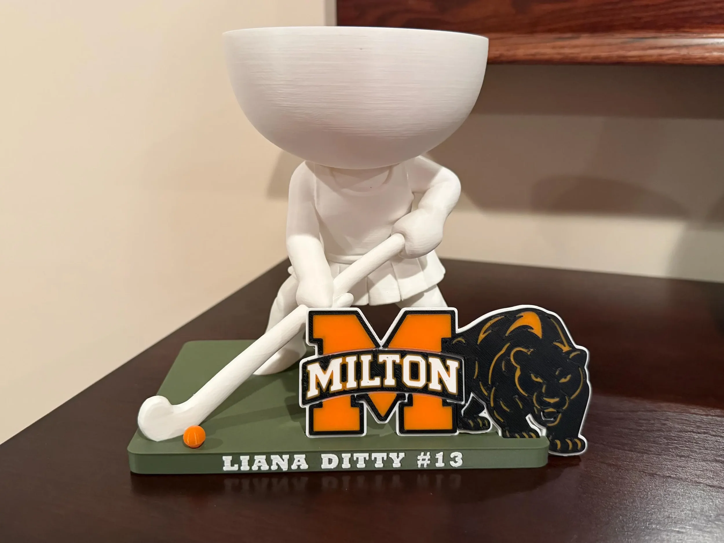 Front view of a field hockey player planter showing the planting bowl