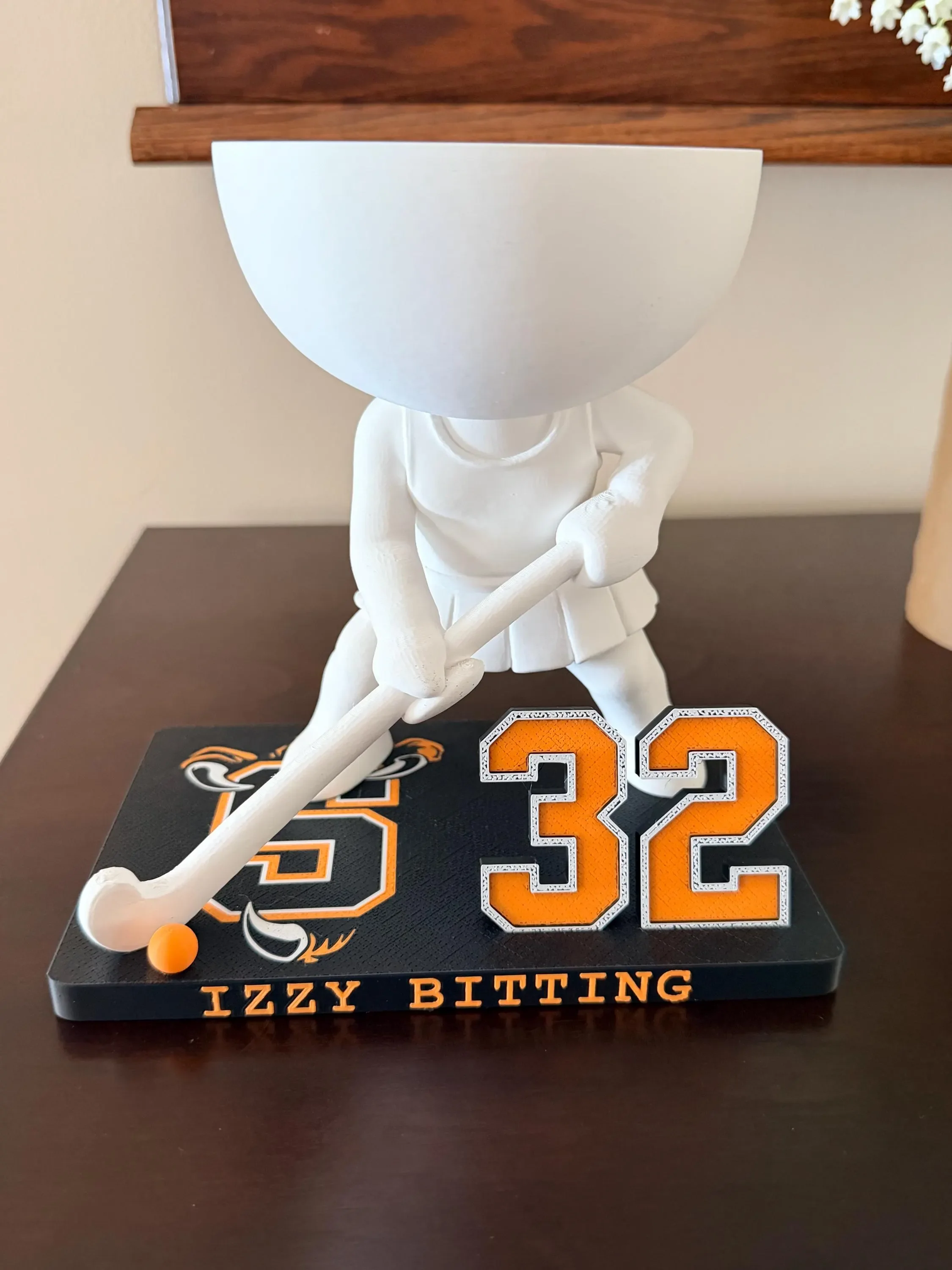 Field hockey player planter in orange and black with the name Izzy Bitting and number 32