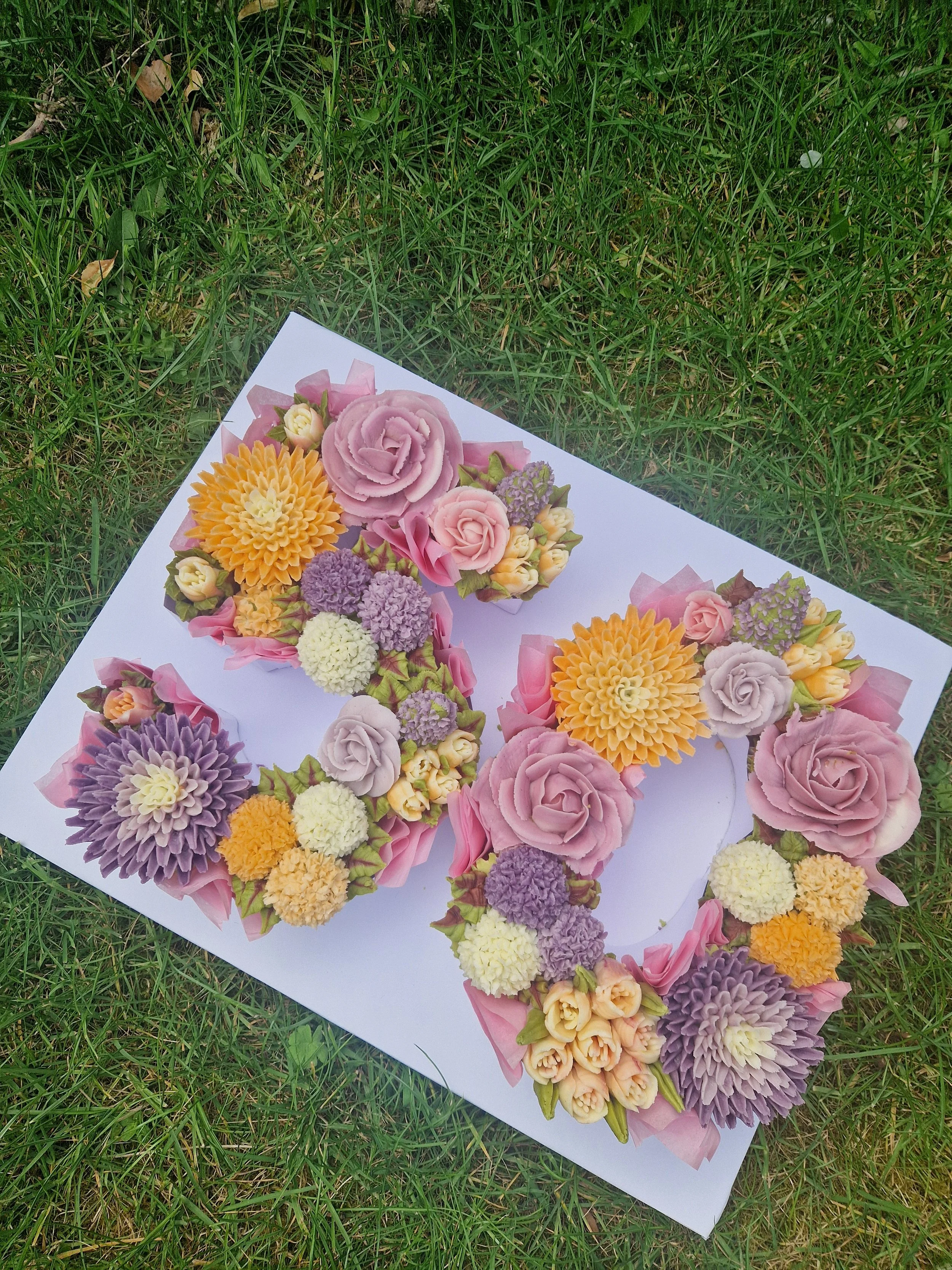 A cake number arrangements laid on grass outdoors.