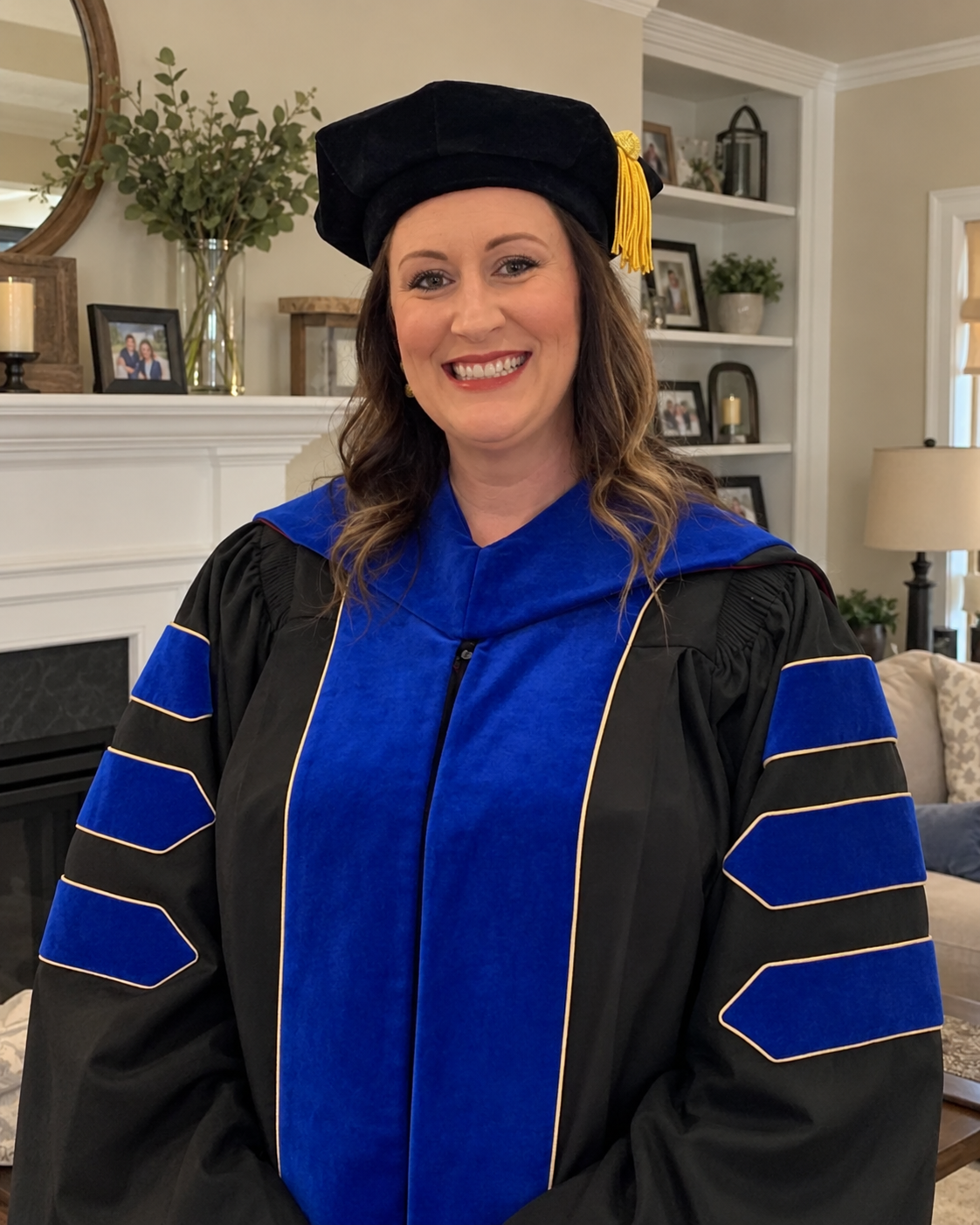 Dr. Sarah Longshore smiling in doctoral academic regalia in a home setting.