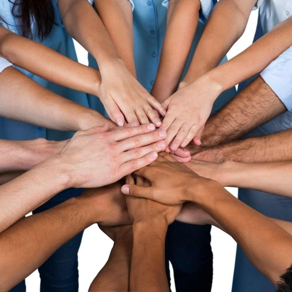 Diverse group of people stacking their hands together in a circle