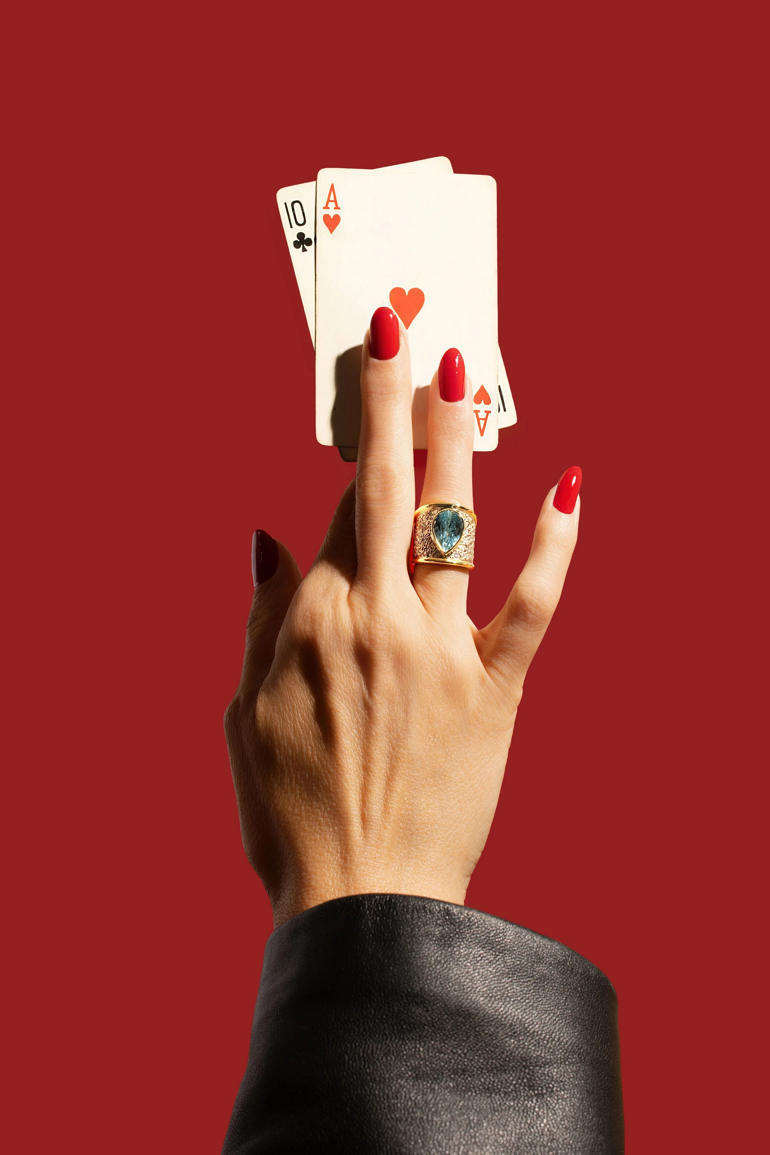 Editorial & Brand — Statement jewelry and a hand of playing cards styled for a cinematic luxury campaign.