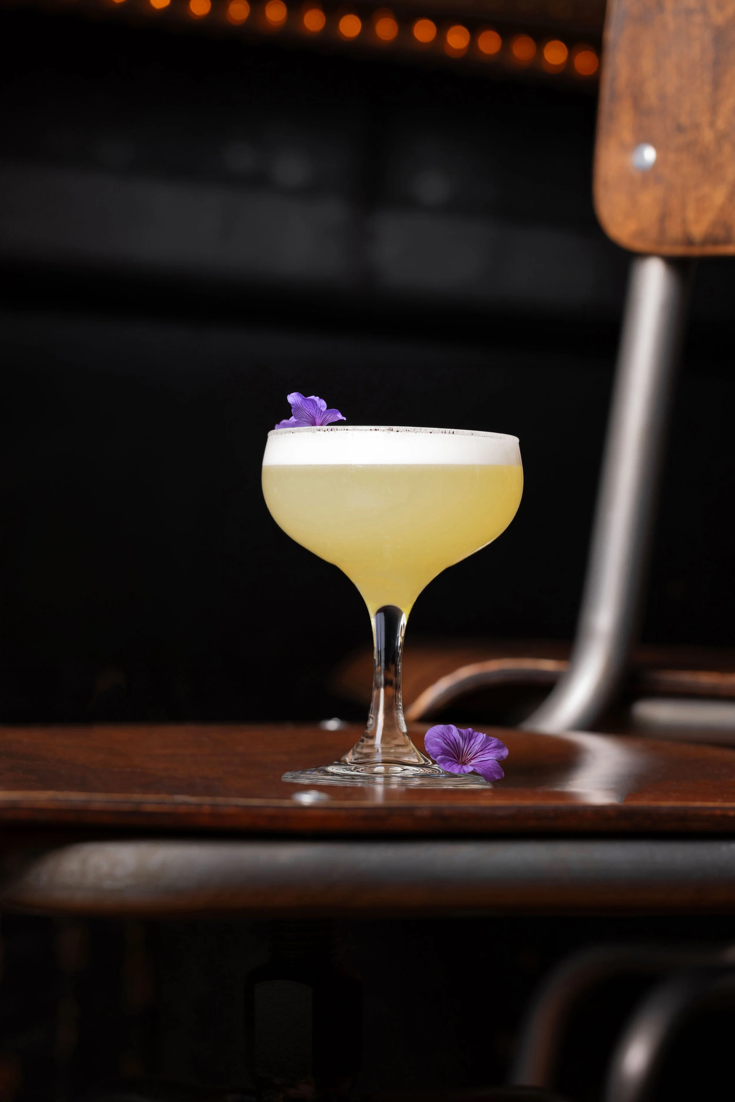 The Pollinator cocktail with edible flower garnish, photographed for a restaurant beverage campaign in Asheville.