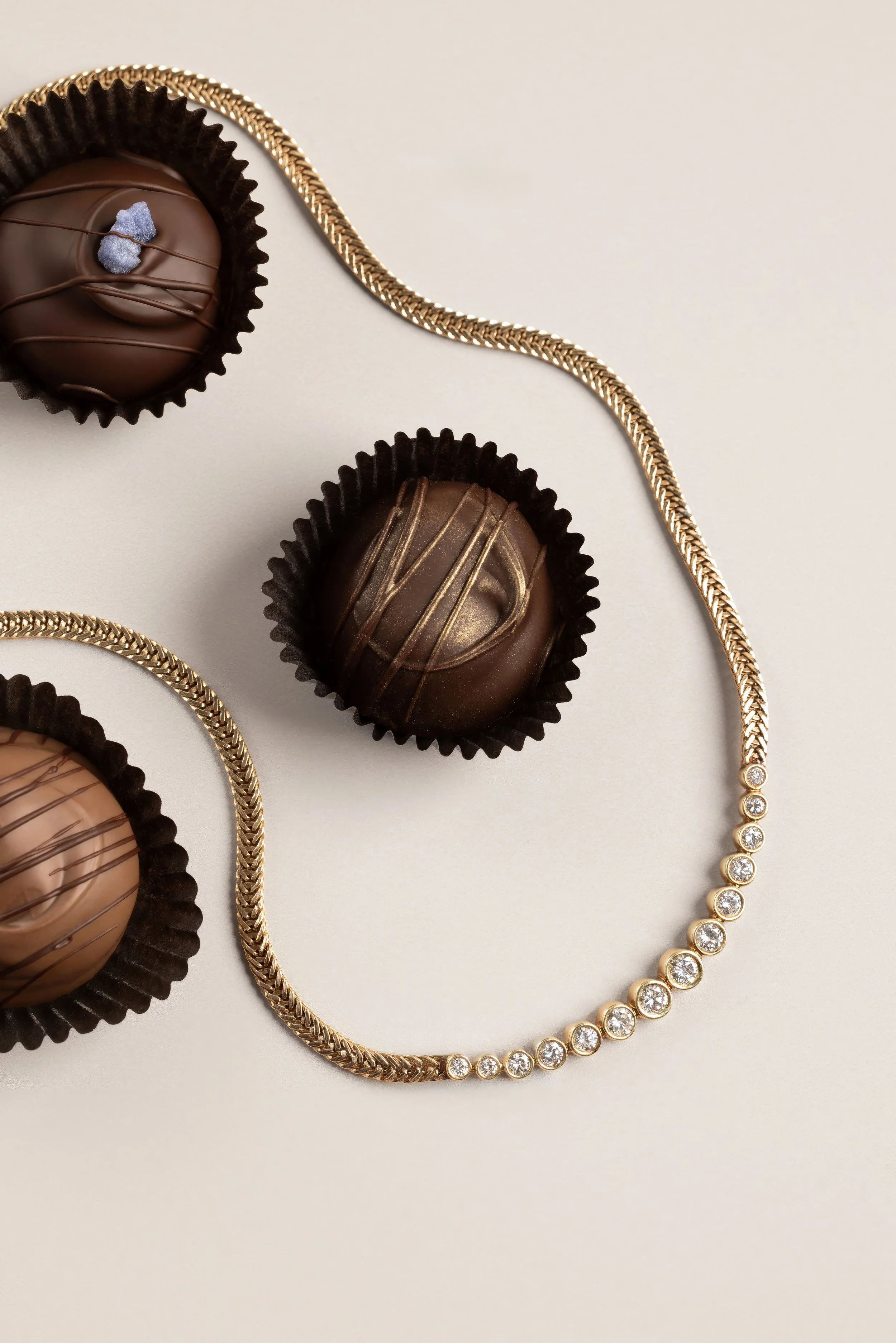 Luxury Jewelry — Diamond necklace styled with a chocolate truffle for a rich editorial still life.