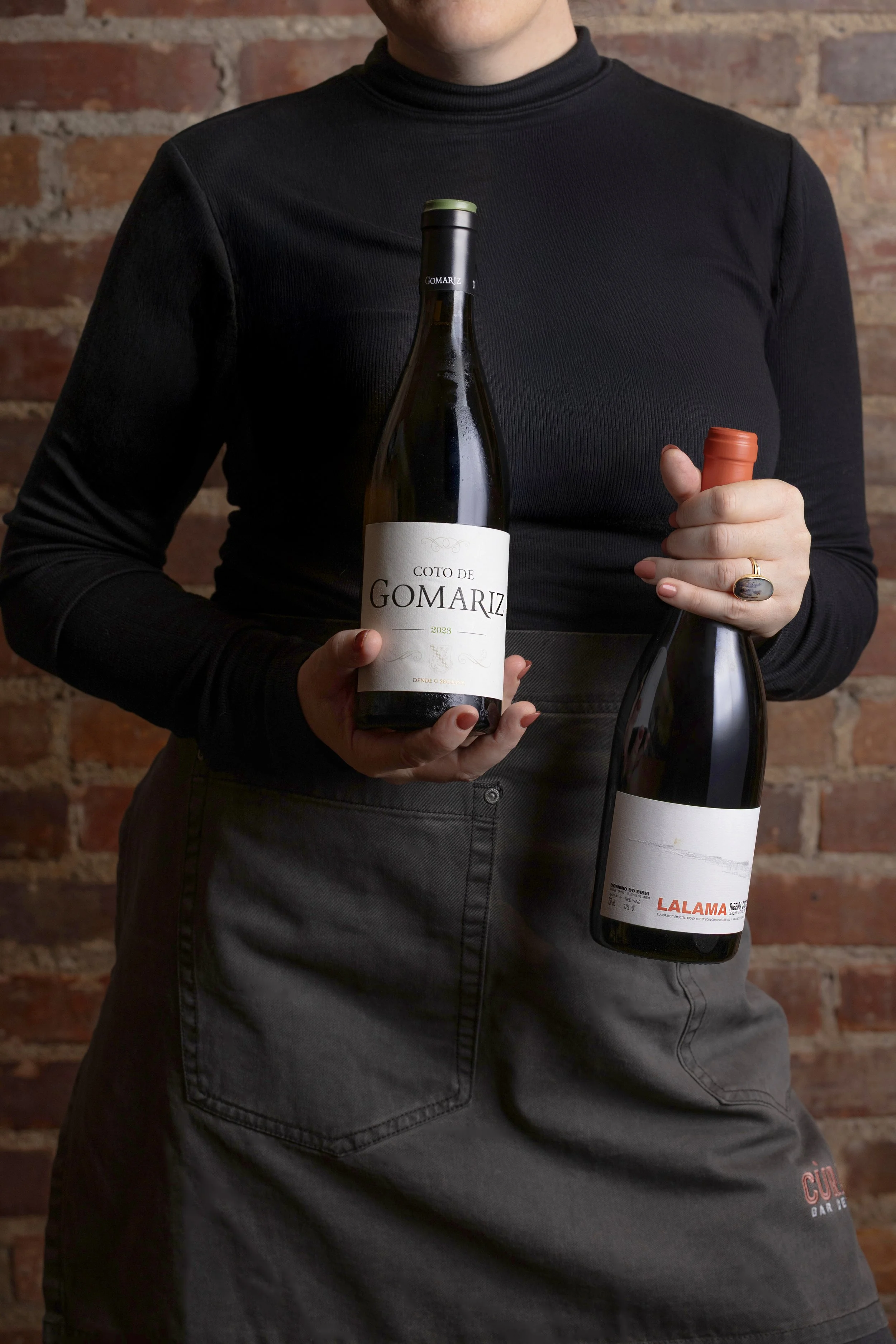 Sommelier holding two wine bottles for a summer beverage campaign, photographed by Fraiche Photography in Asheville, North Carolina.