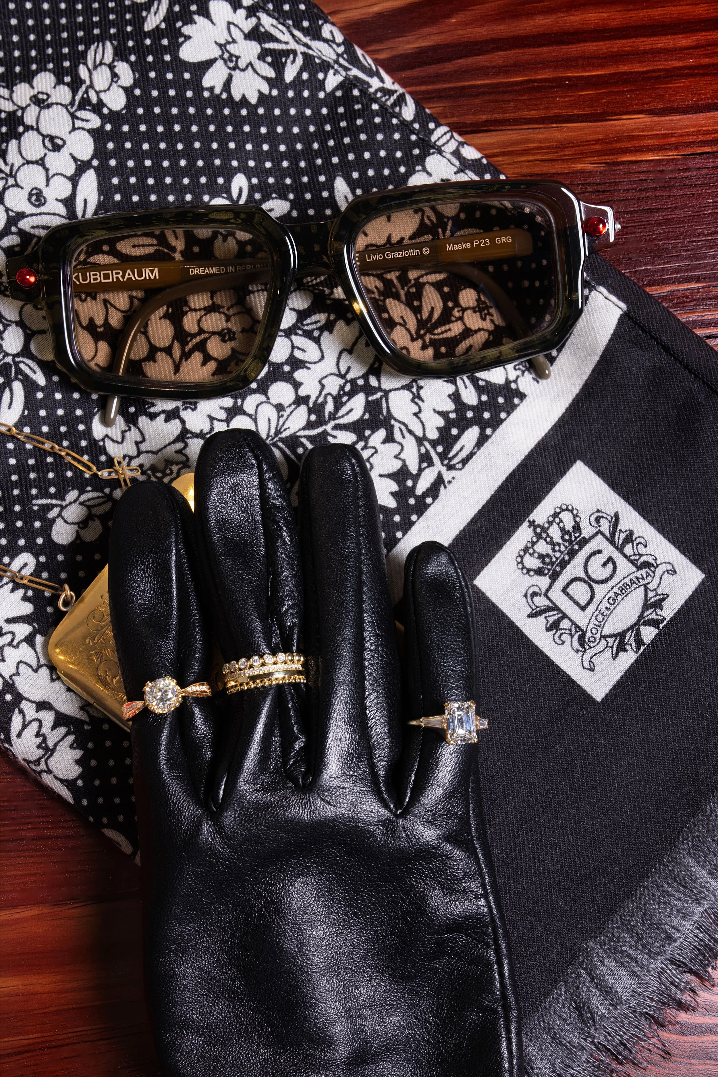 Luxury Jewelry — Statement rings and accessories arranged in a cinematic spy-inspired editorial flat lay.