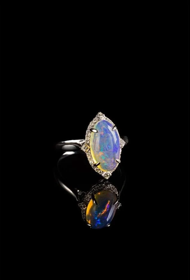 Luxury Jewelry — Celestial opal statement ring photographed against black for a dramatic product editorial.