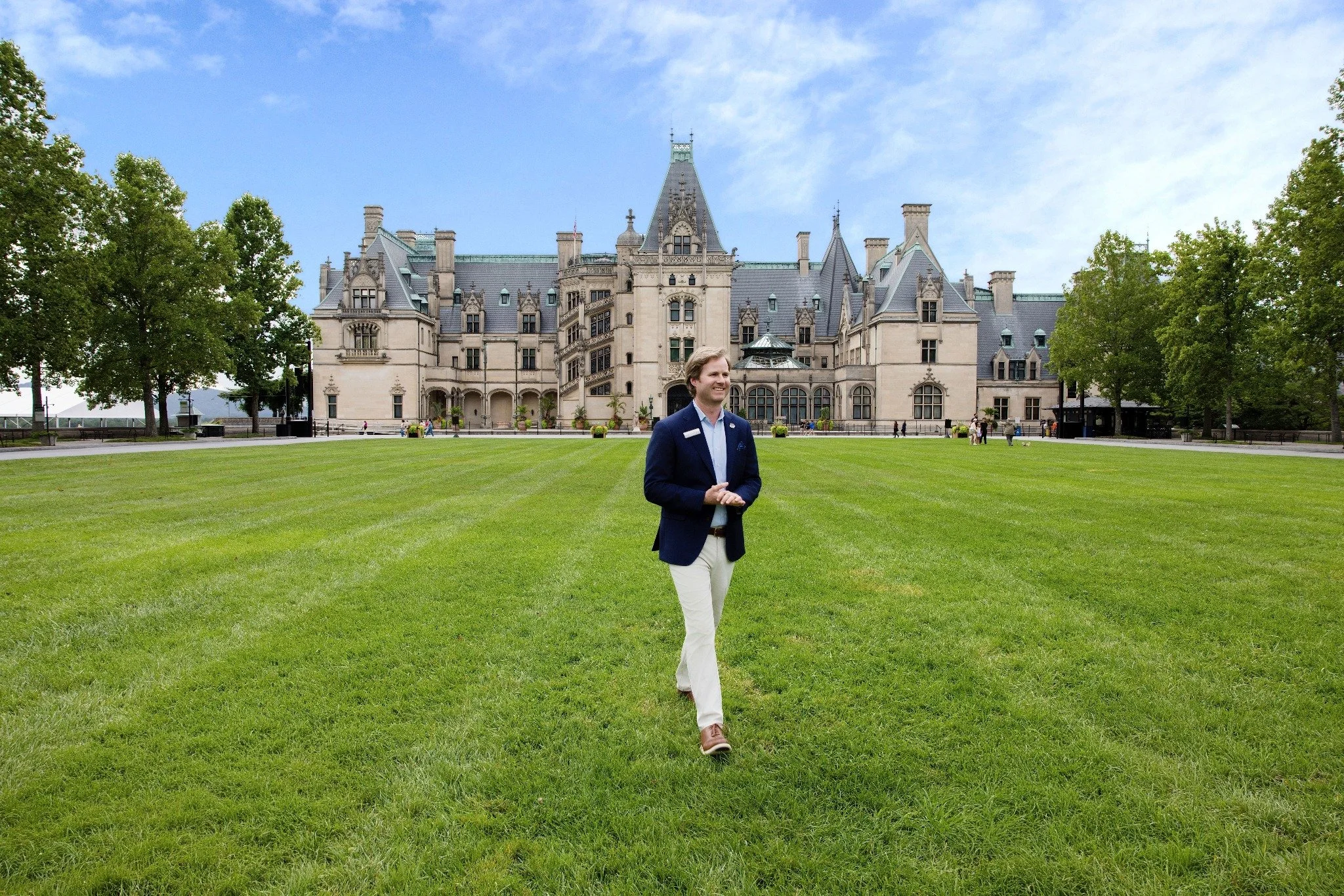 Chase Pickering walking across the lawn in front of Biltmore Estate in Asheville, photographed for Edible Asheville.