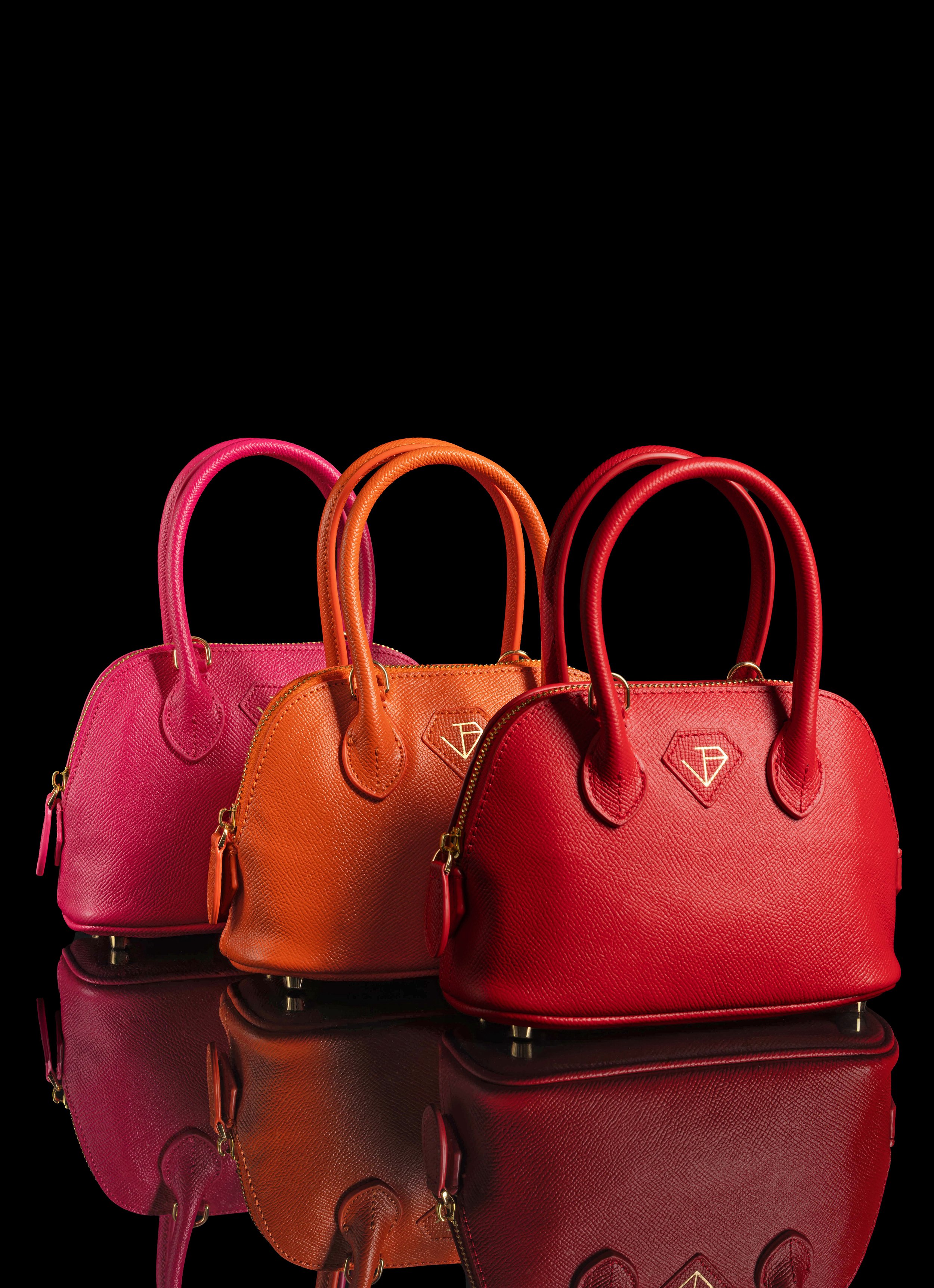 Editorial & Brand — Trio of leather handbags photographed in a clean, editorial studio composition.