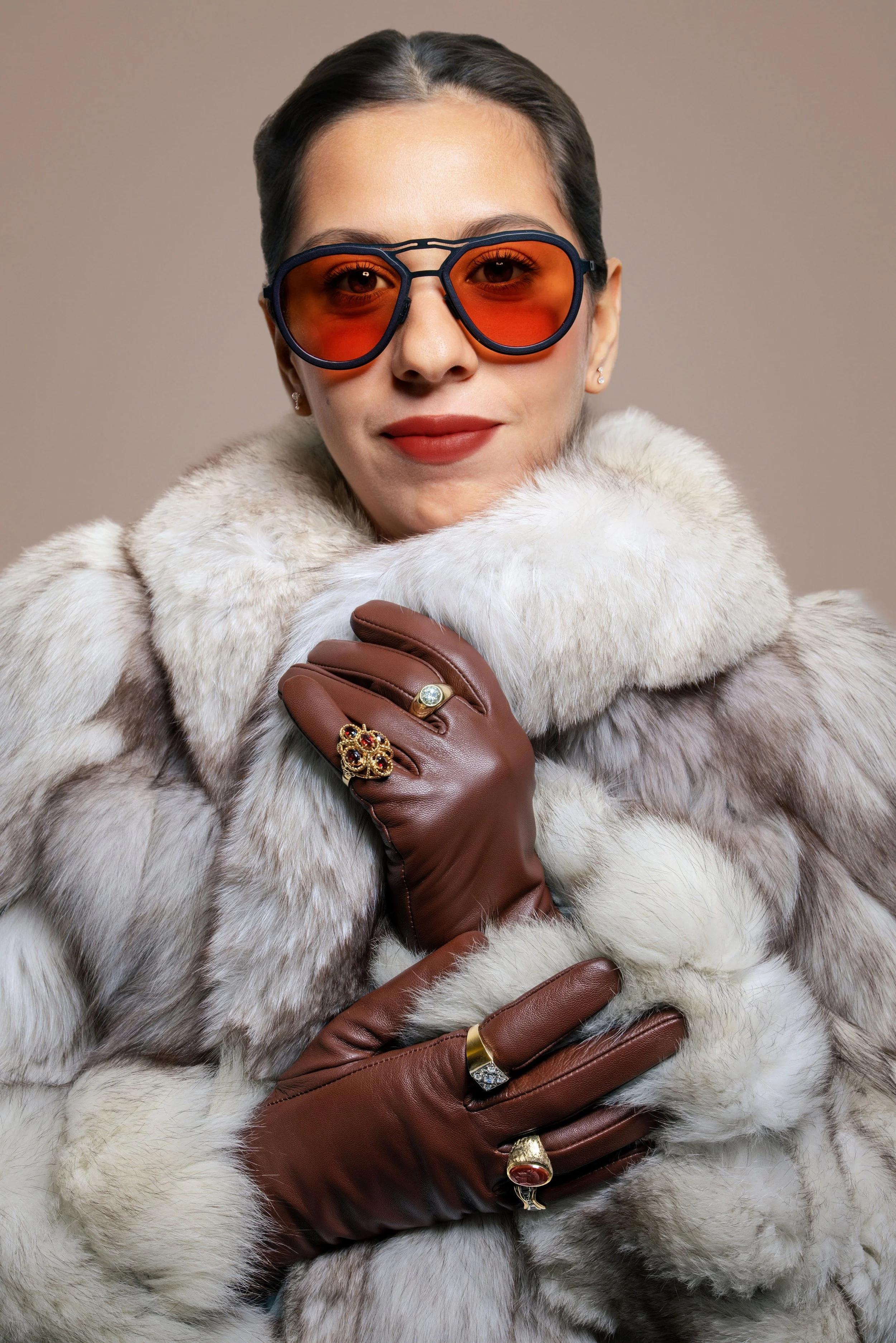 Model wearing statement rings, red sunglasses, and white fur in a luxury jewelry editorial by Fraiche Photography.